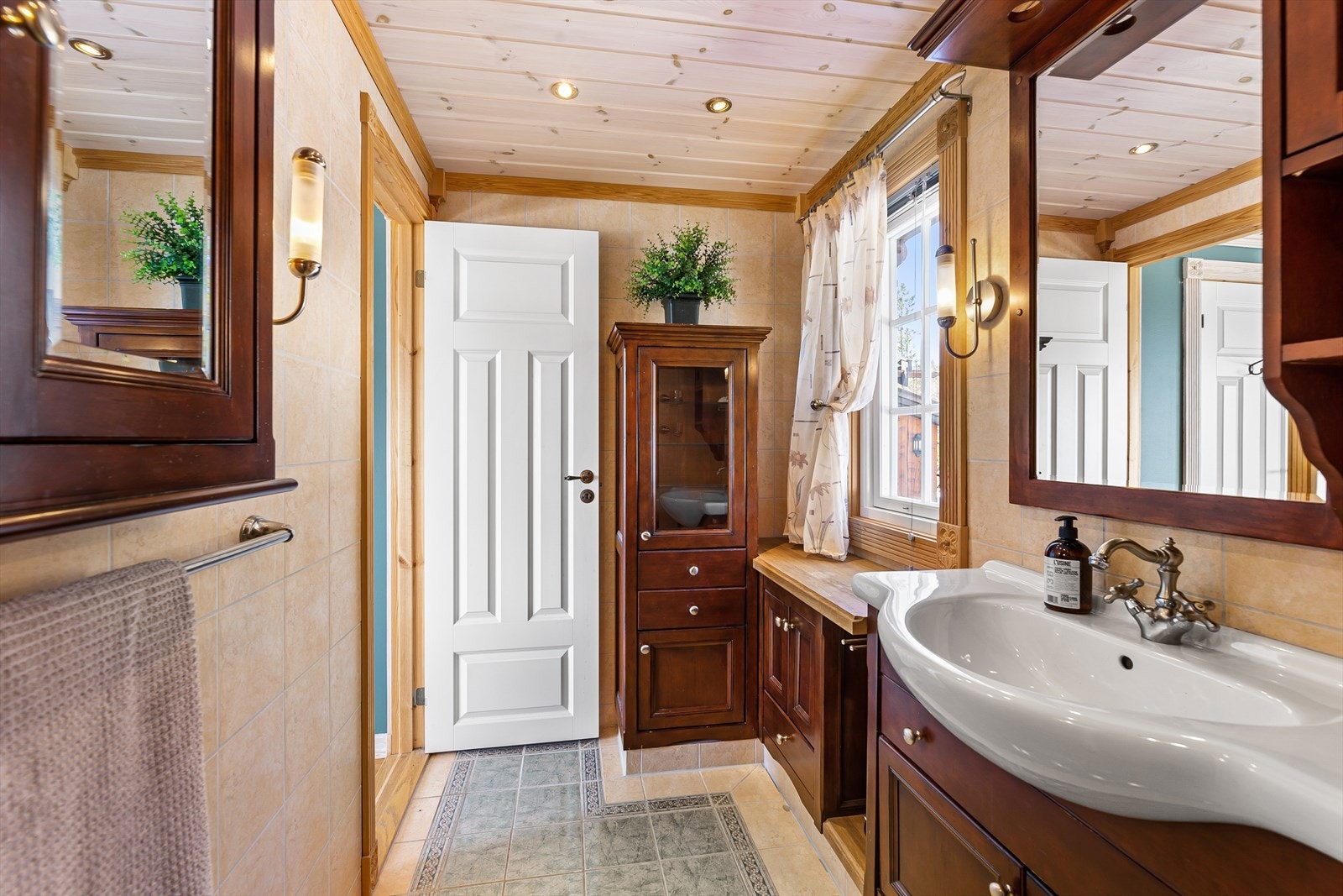 Badet er innnredet med servant, dusjhjørne og baderomsinnredning. Galleribilde