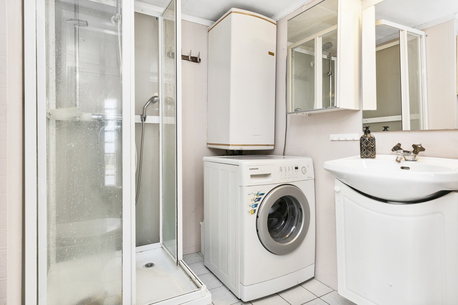 Badet har dusjkabinett, servantinnredning, wc, varmtvannsbereder og opplegg for vaskemaskin. Galleribilde