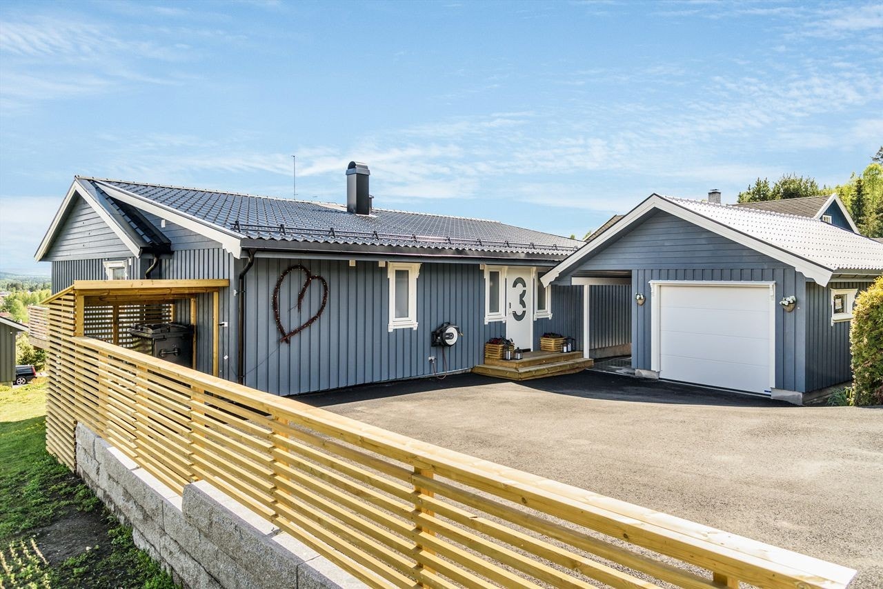 Fin asfaltert gårdsplass og nyere garasje. Galleribilde