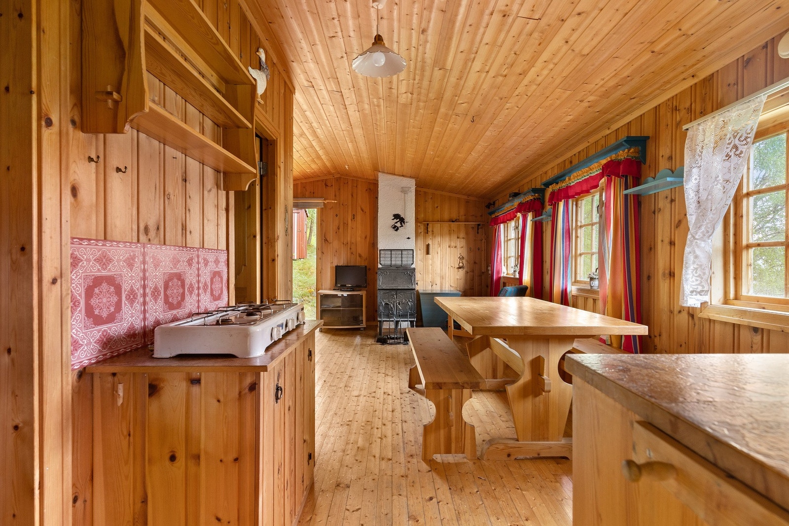 Kjøkken/stue i hytta. Hytta er en tradisjonell norsk brukshytte med furu i himling, furu på vegger og furugulv. Galleribilde