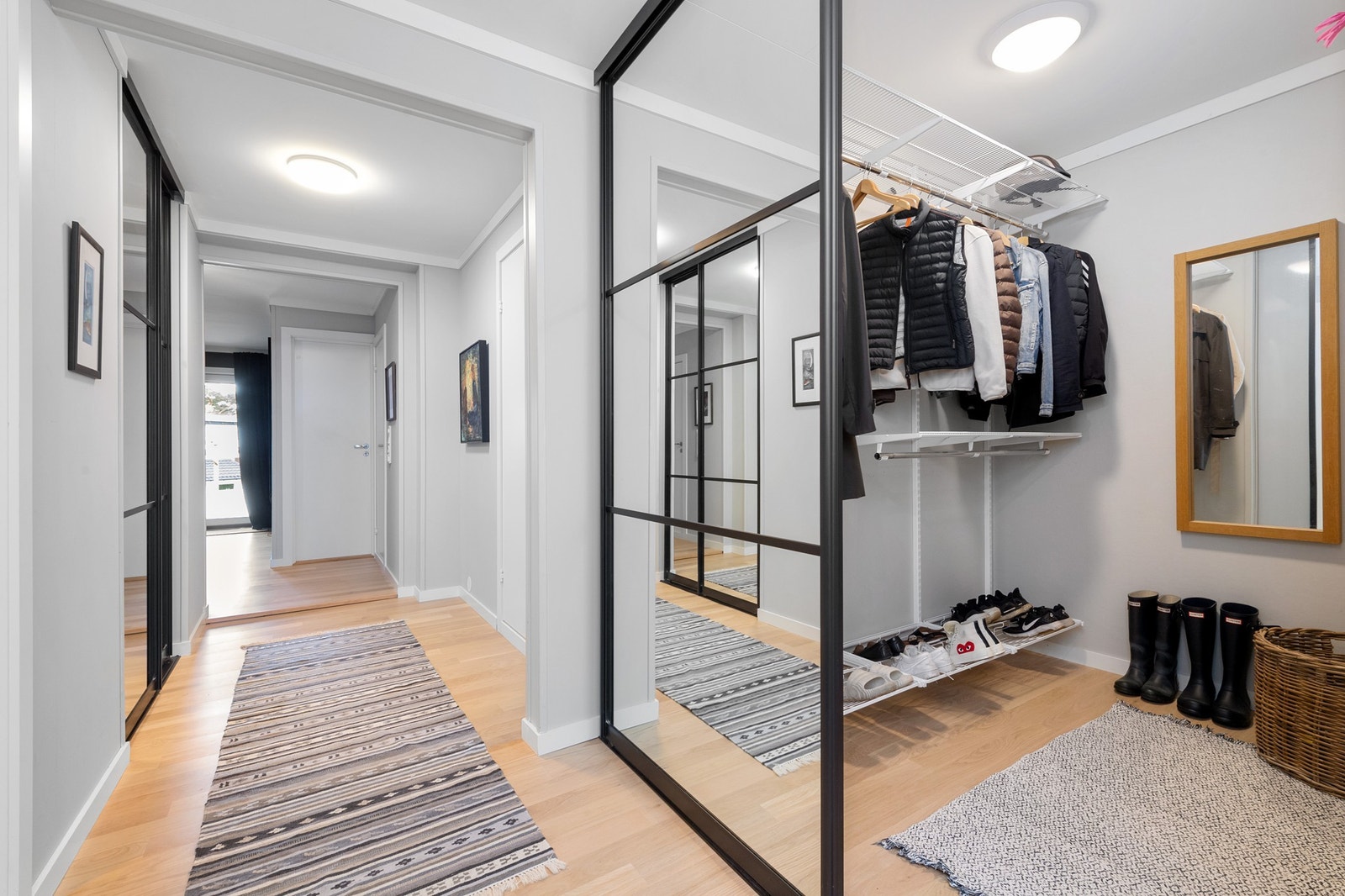Garderobe ved entré, adskilt med skyvedører med speilfronter Galleribilde