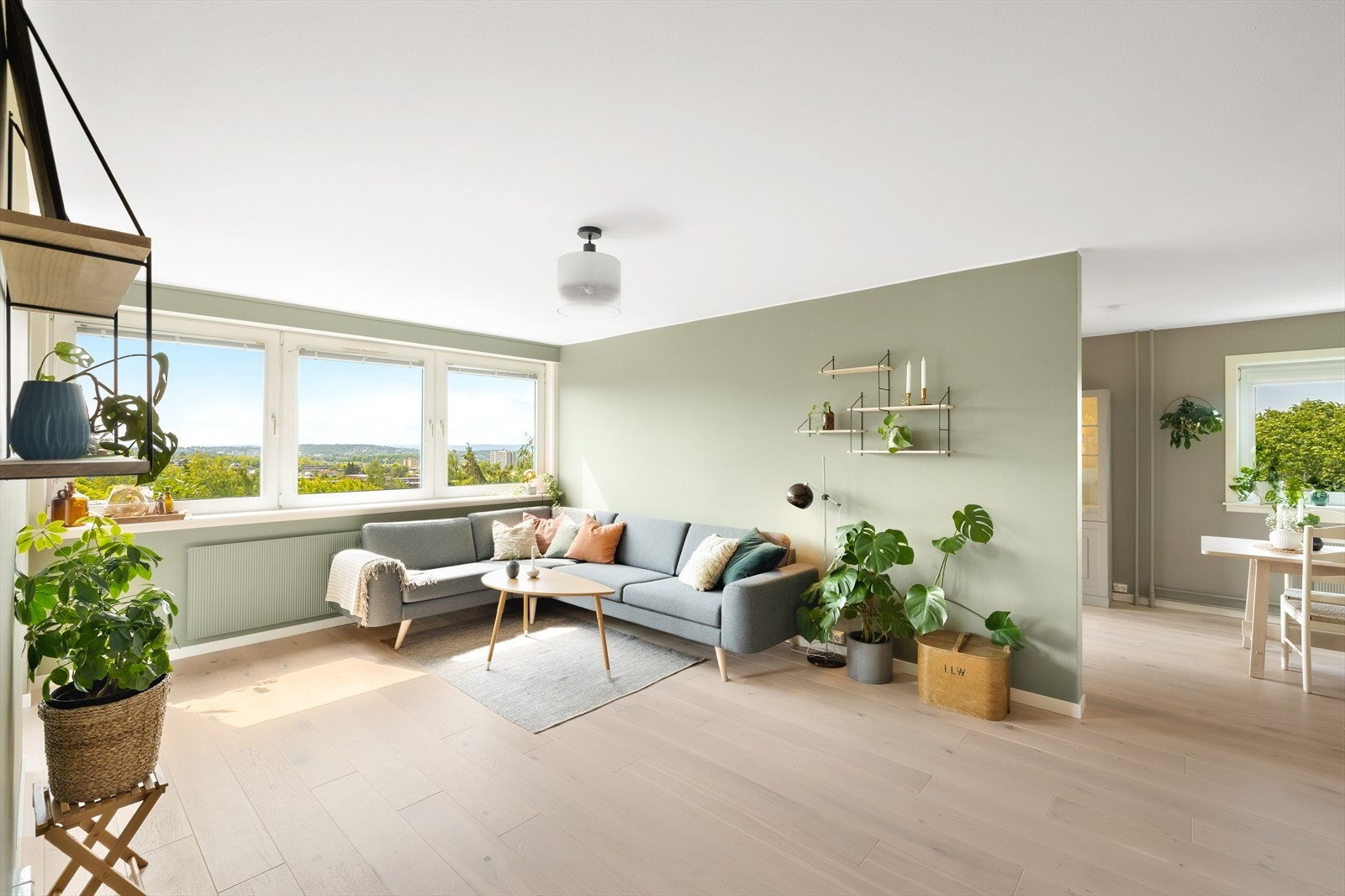 Stue med parkett på gulv, 1 vegg med beiset panel, malte slette vegger og mal tak. Stuen er enkel og møblere og med store vindusflater føles den som lys og luftig som skaper en hyggelig atmosfære. Galleribilde