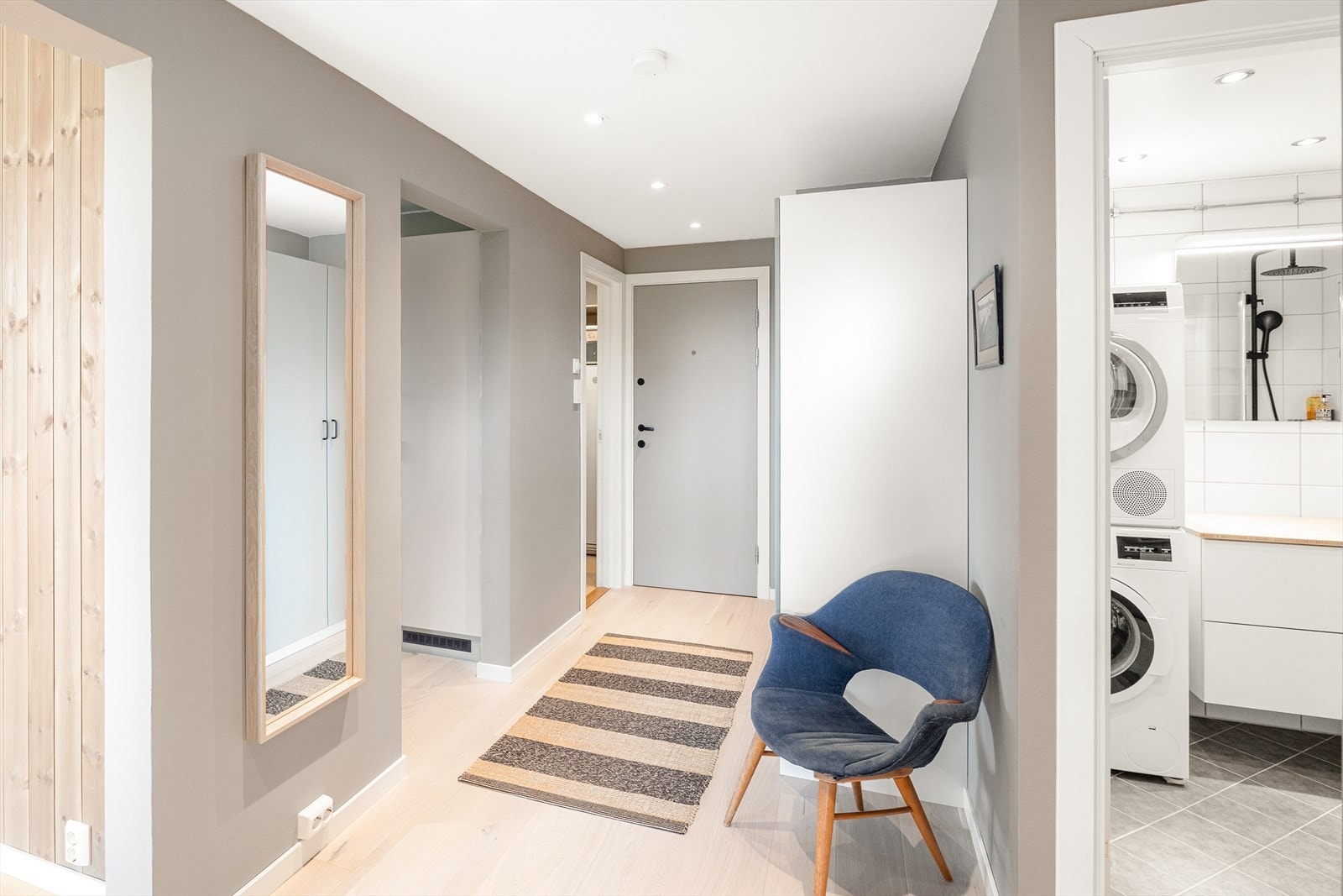 Romslig og innbydende entré med parkett på gulv, malte slette vegger og malt tak med downlights. Galleribilde