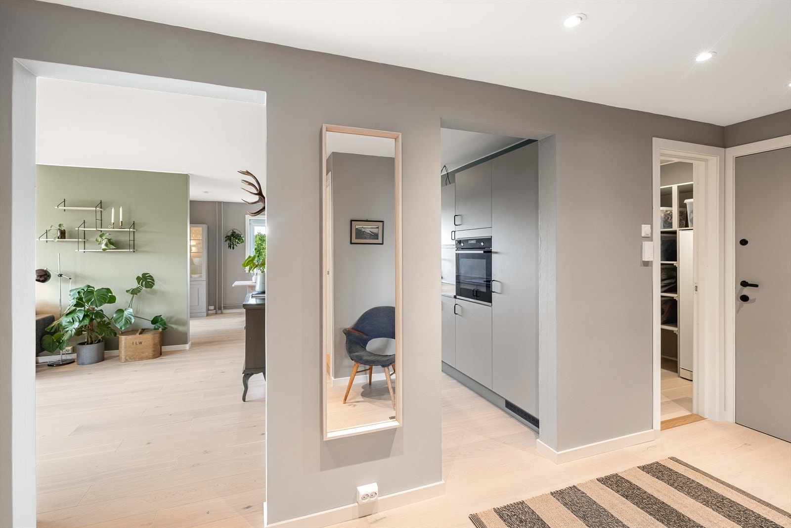 Romslig og innbydende entré med parkett på gulv, malte slette vegger og malt tak med downlights. Galleribilde