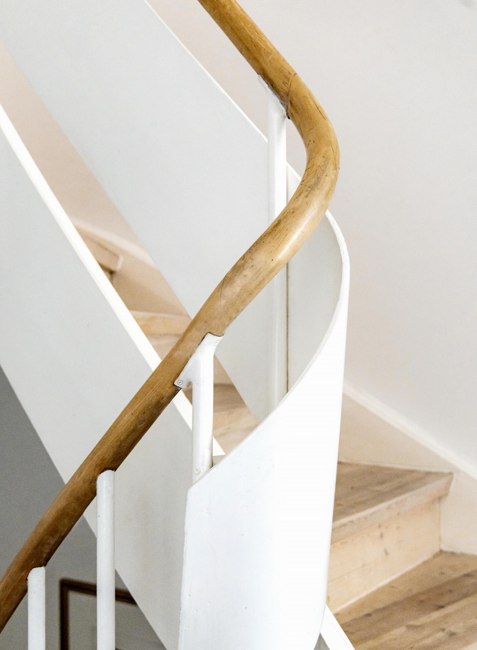 I enden av entreen går en typisk, svungen funkistrapp i lyspigmentert heltre med hvite vanger mellom etasjene. Galleribilde