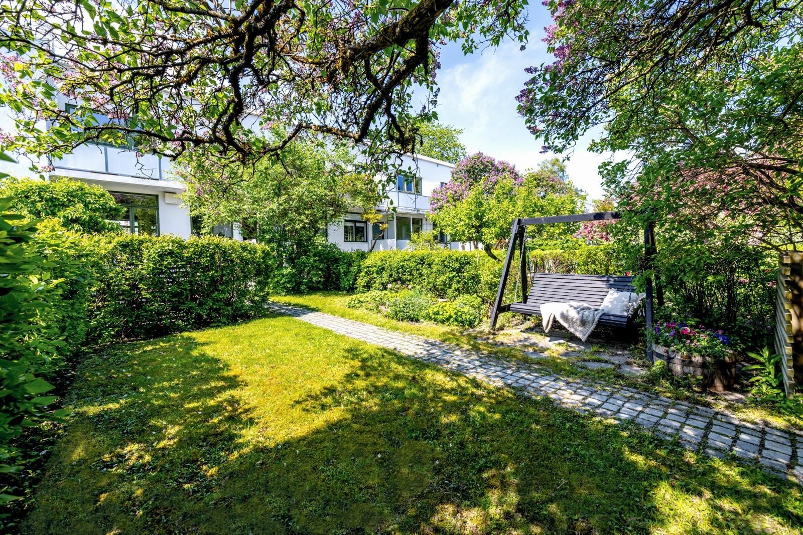 Frodig hage med sol fra tidlig morgen til ca kl 18. En god bok og så gynge litt sakte i hammocken under syrinene kanskje? Galleribilde