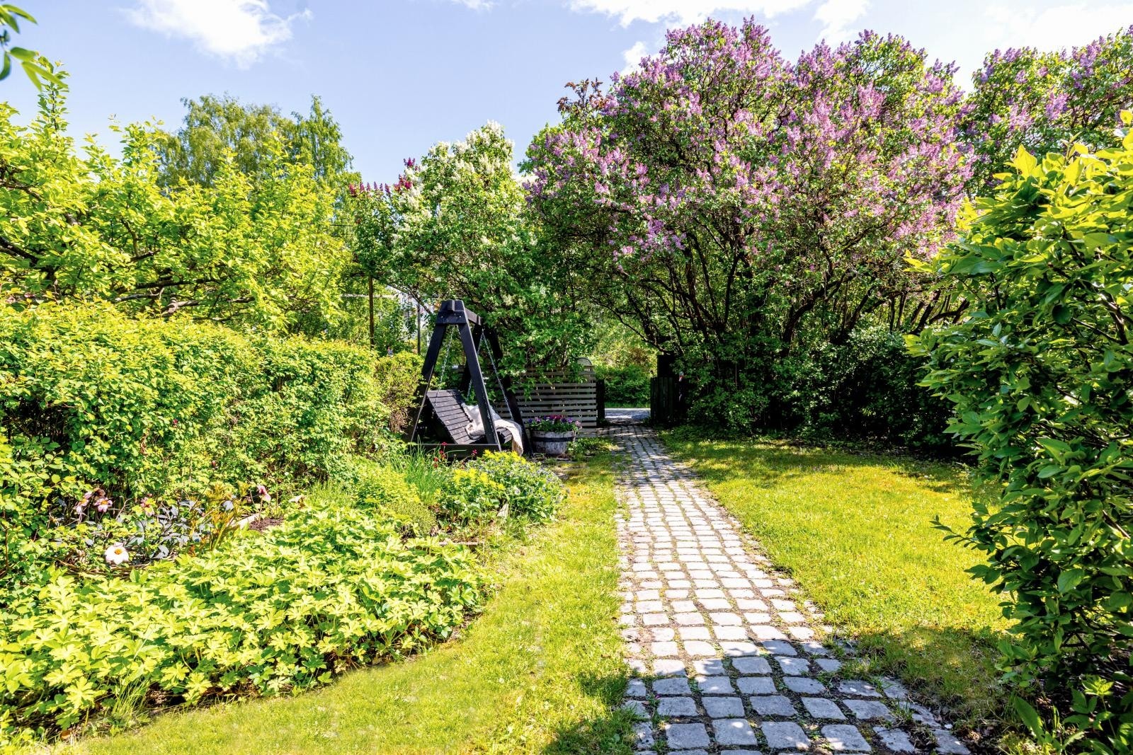 Brosteinslagt hagegang gjennom forhagen mot hageporten og gårdsplassen utenfor. Hyggelig utsyn! Galleribilde