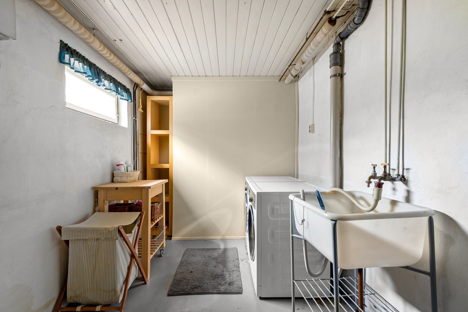 Vaskerommet er en klassisk vaskekjeller med malt betonggulv og malte murvegger. Rommet har stativ med skyllekum i plast, samt opplegg for vaskemaskin og tørketrommel. Galleribilde