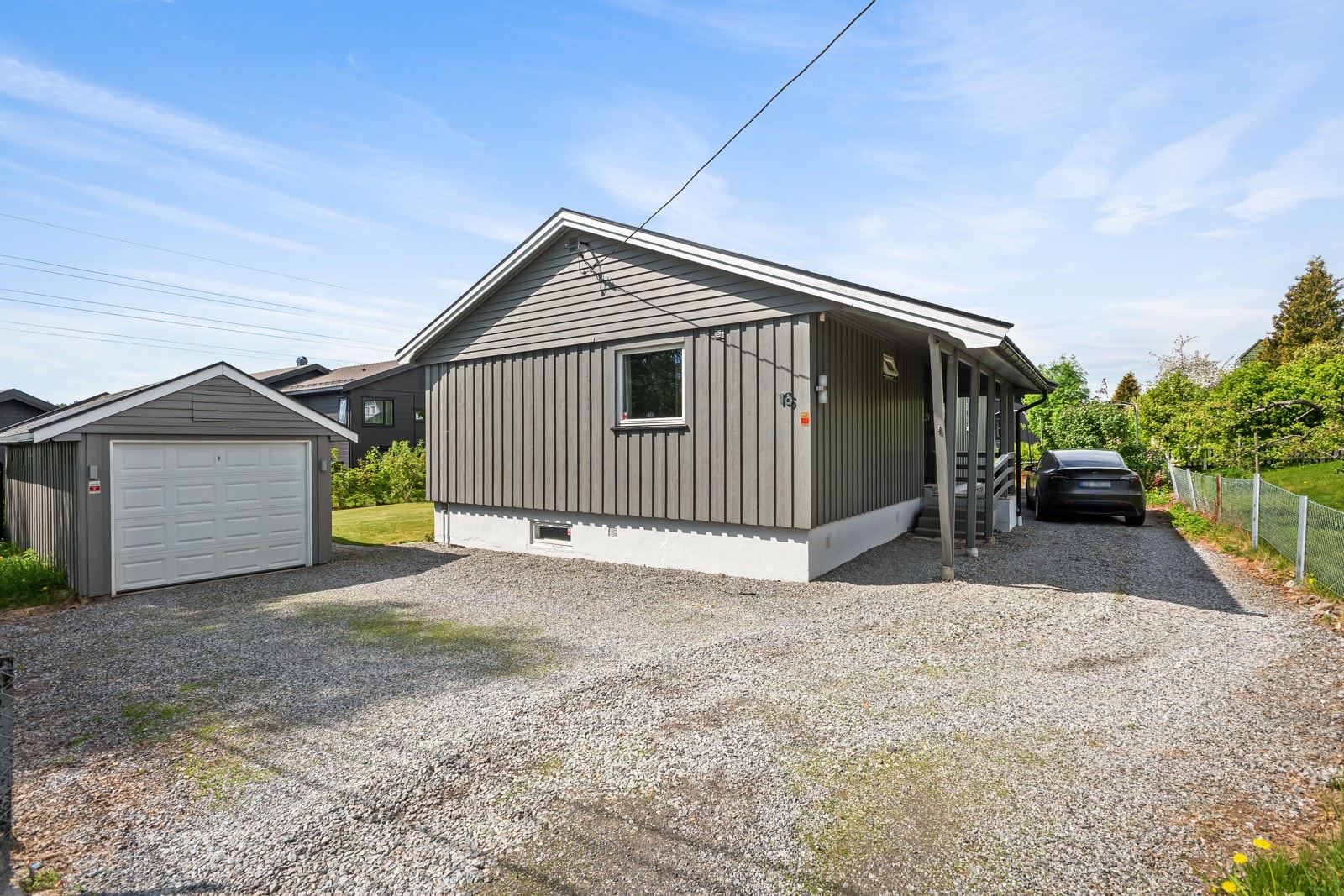 Gårdsplassen er gruset foran garasjen og videre forbi inngangspartiet på nordsiden av huset. Galleribilde
