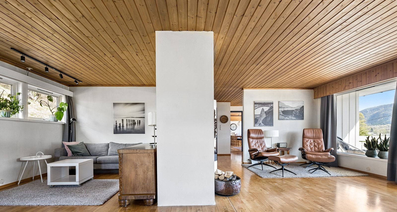 Romslig stue med plass til flere sittegrupper Galleribilde