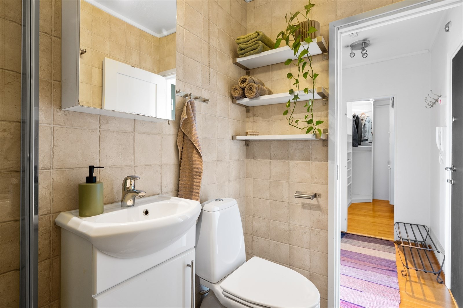 Baderomsinnredningen består av servant med skapinnredning, frittstående toalett og dusjhjørne med dusjdører i hedret glass. Galleribilde