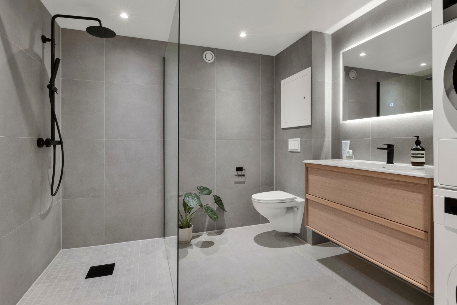 Badet har stor dusjsone, baderomsmøblement i eik fra Haven, speil med integrert, dimbar belysning og downlights i tak. Galleribilde