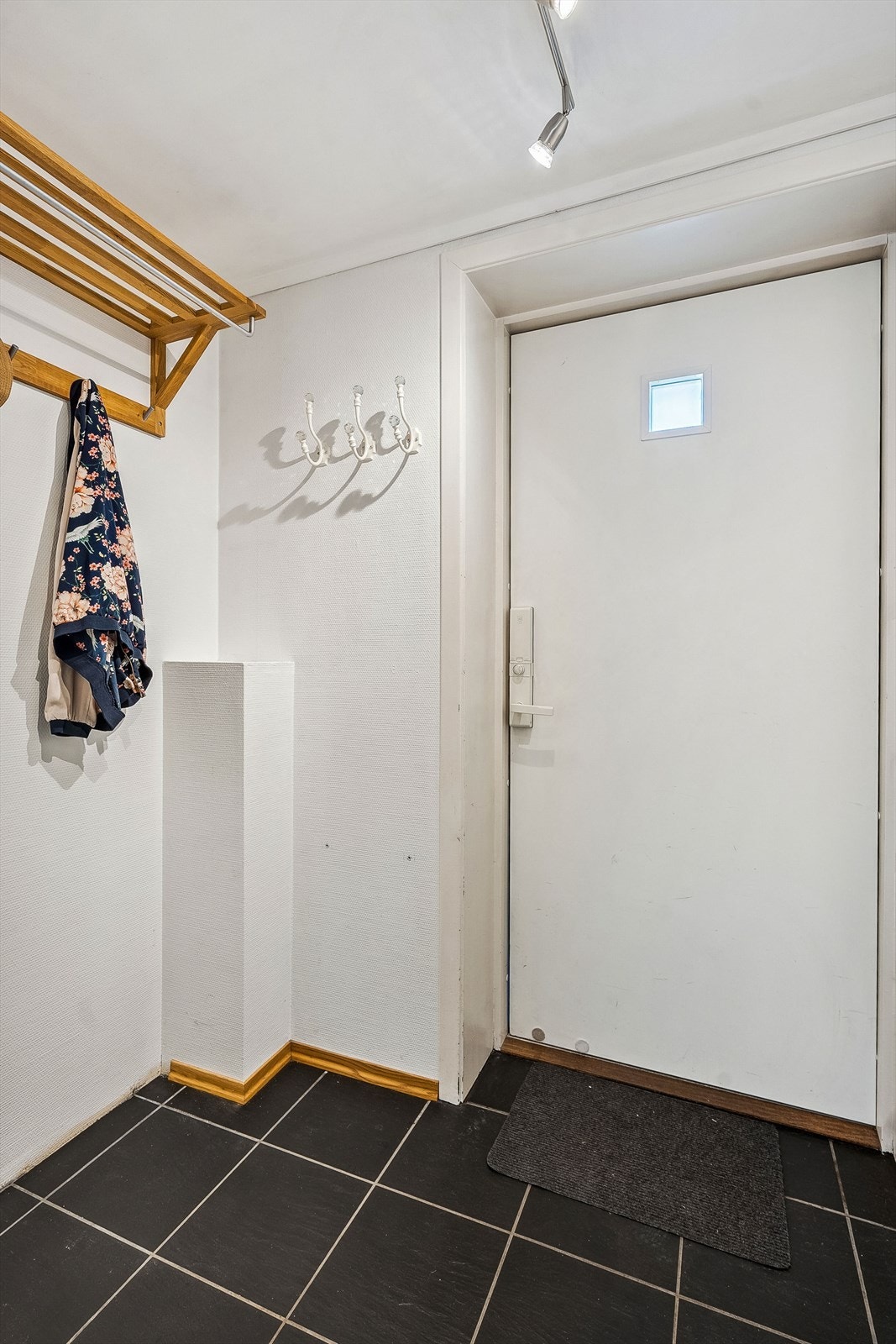Fliser i vindfang og plass til å henge fra seg yttertøy og sko. Et hyggelig, trivelig hjem å bo i - og ønske gjester velkommen! Galleribilde
