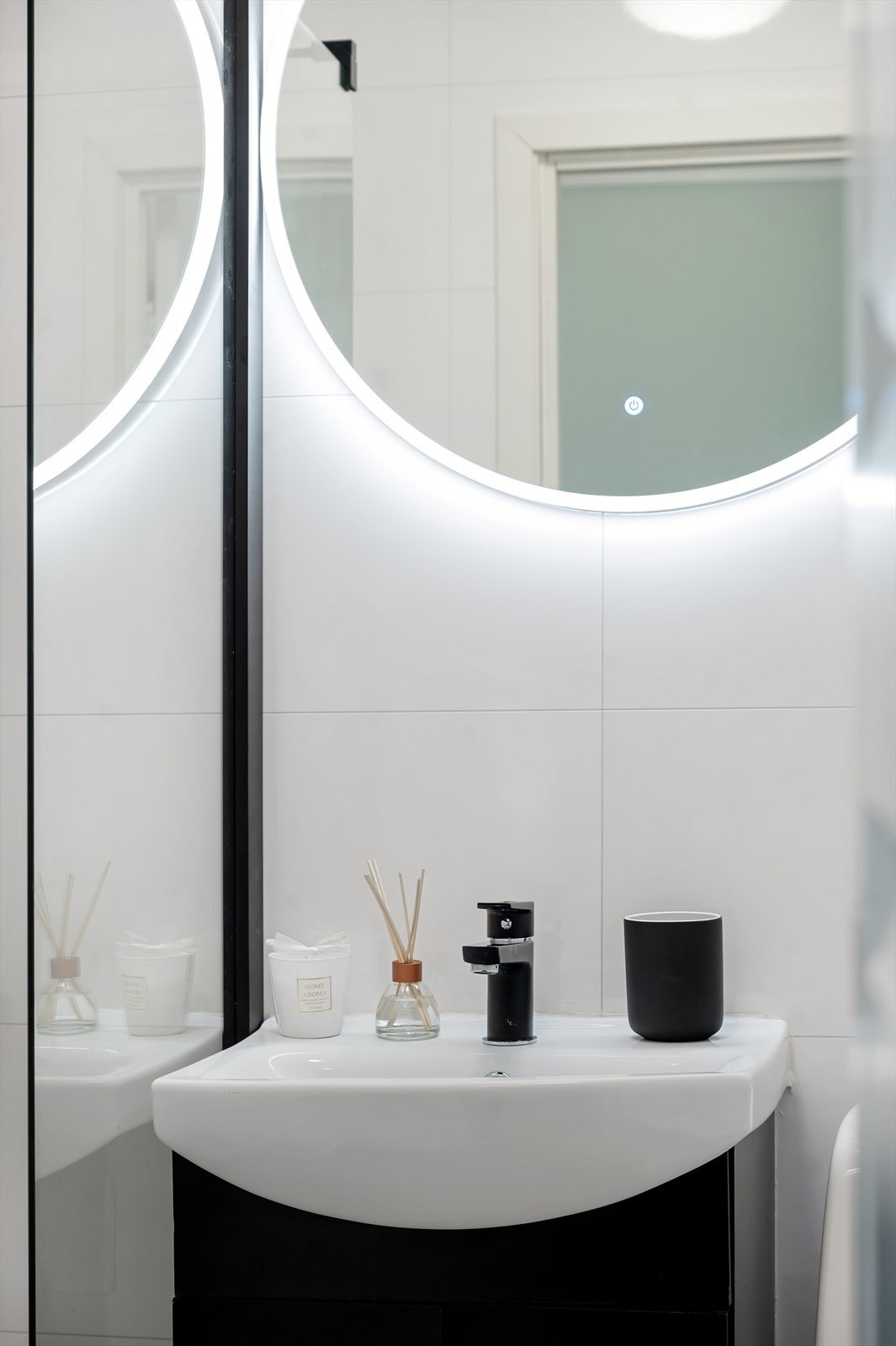 Badet er innredet med gulvstående toalett, servant med servantskap og med tilhørende speil med belysning samt dusjhjørne med regndusj og armatur i smijern Galleribilde