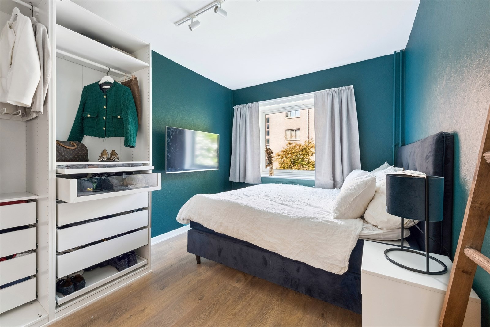 Romslig soverom med plass til stor seng, nattbord og kommode Galleribilde