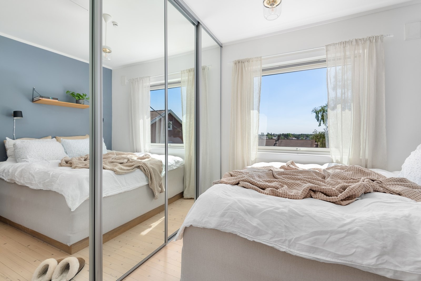 En stor speil-skyvedørsgarderobe fyller den ene veggen. Galleribilde