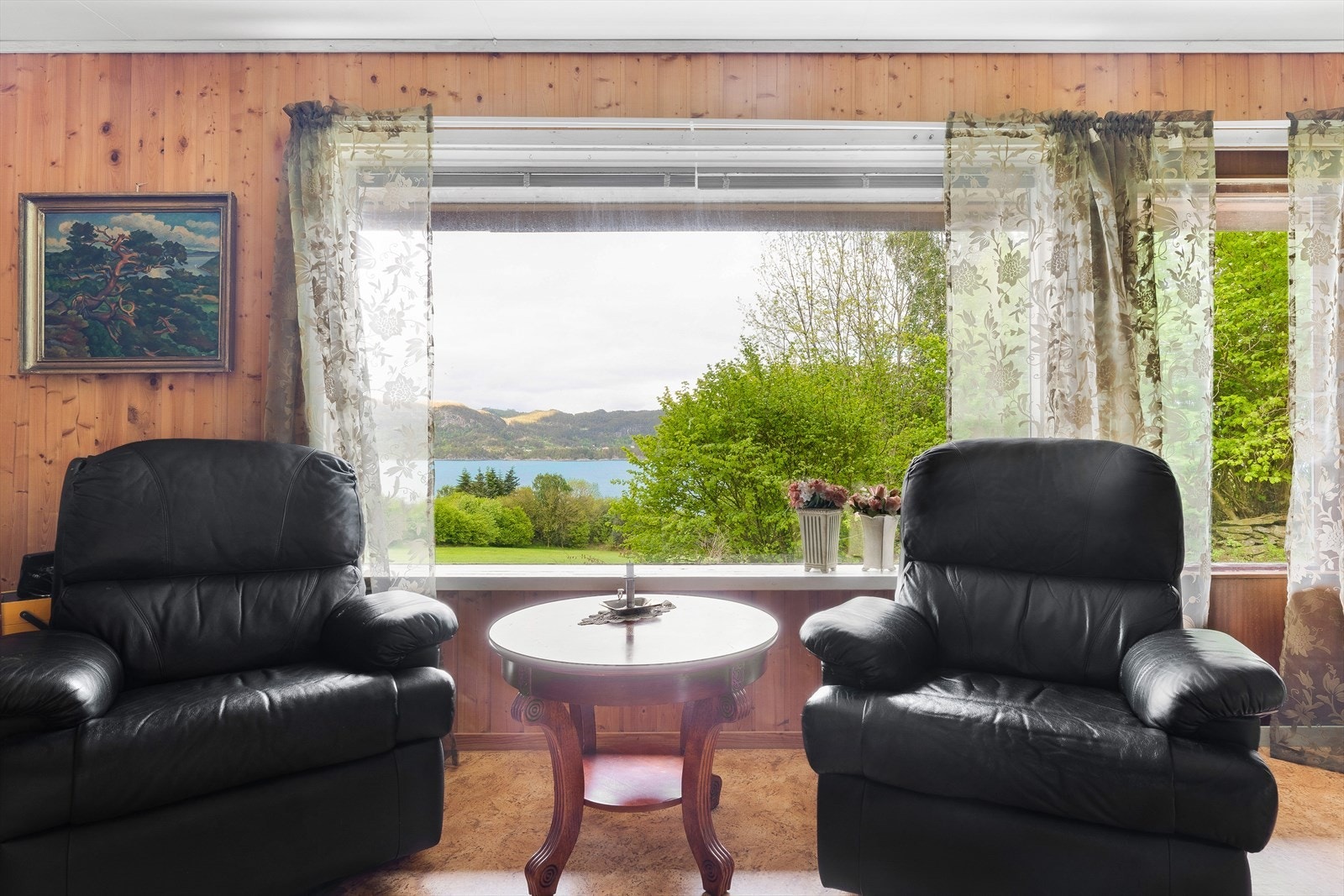 Stuen har store vinduer som slipper inn mye naturlig lys. Galleribilde