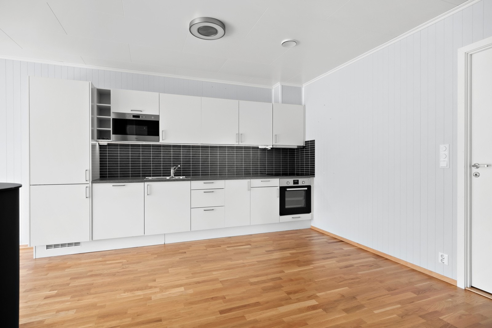 Kjøkeninnreiing med glatte frontar og benkeplate av laminat. Av kvitevarer er det kjøl- og fryseskap, oppvaskmaskin, platetopp, micro og steikeovn. Galleribilde