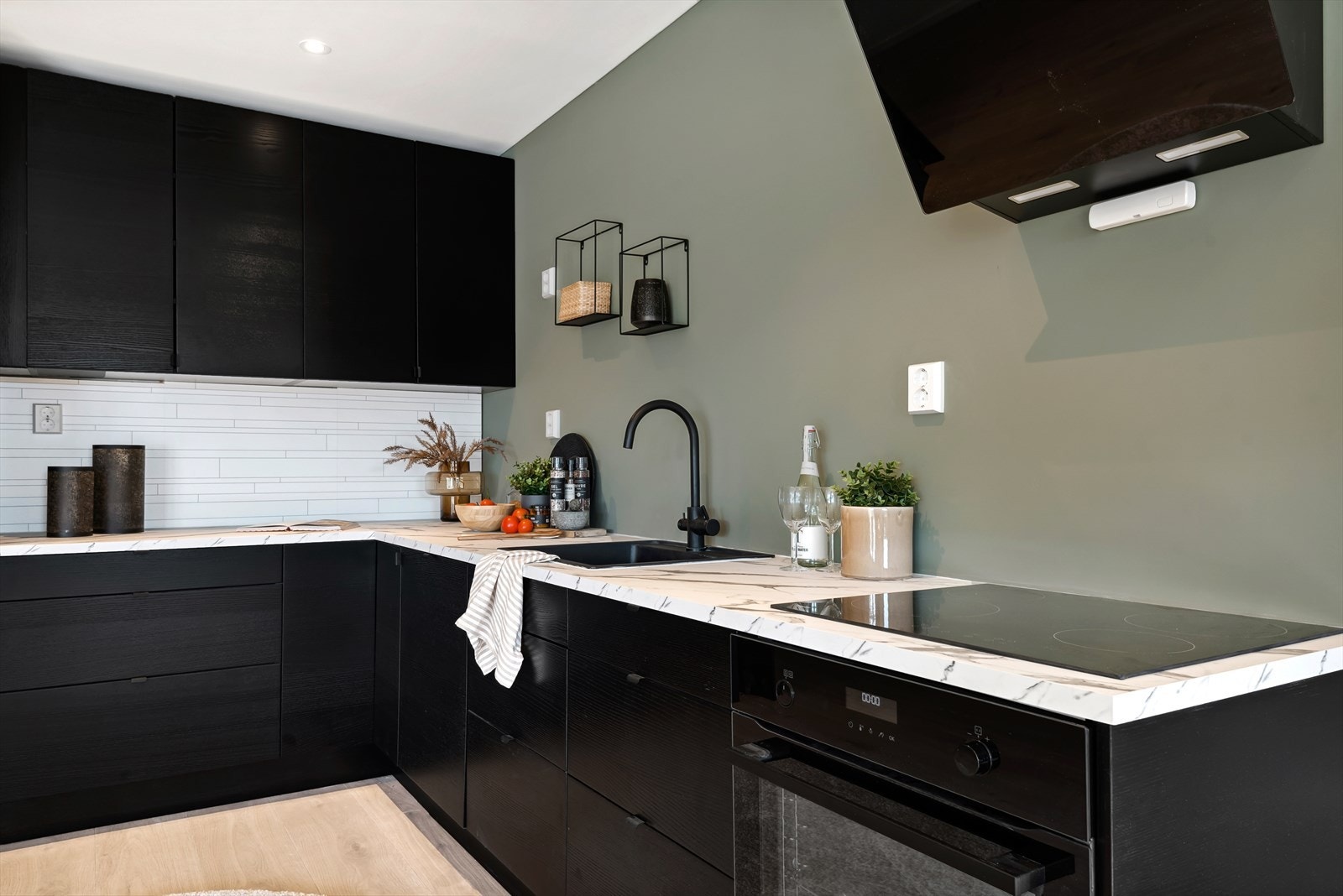 Moderne kjøkken med lys benkeplate. Elektrisk avtrekk over komfyren Galleribilde