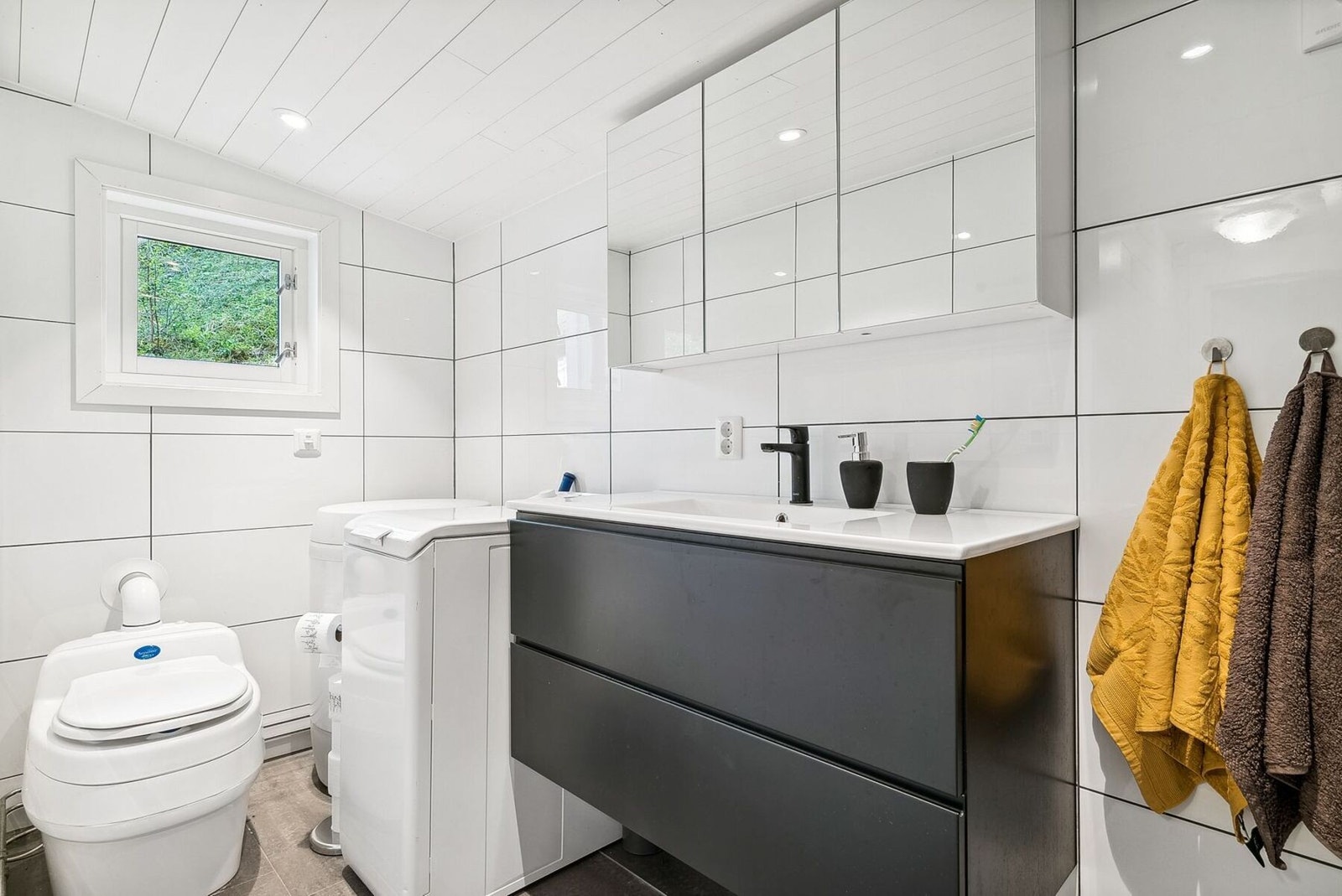 Meget pent bad med dusjnisje, separett wc, servant med skuffer og opplegg for vaskemaskin Galleribilde