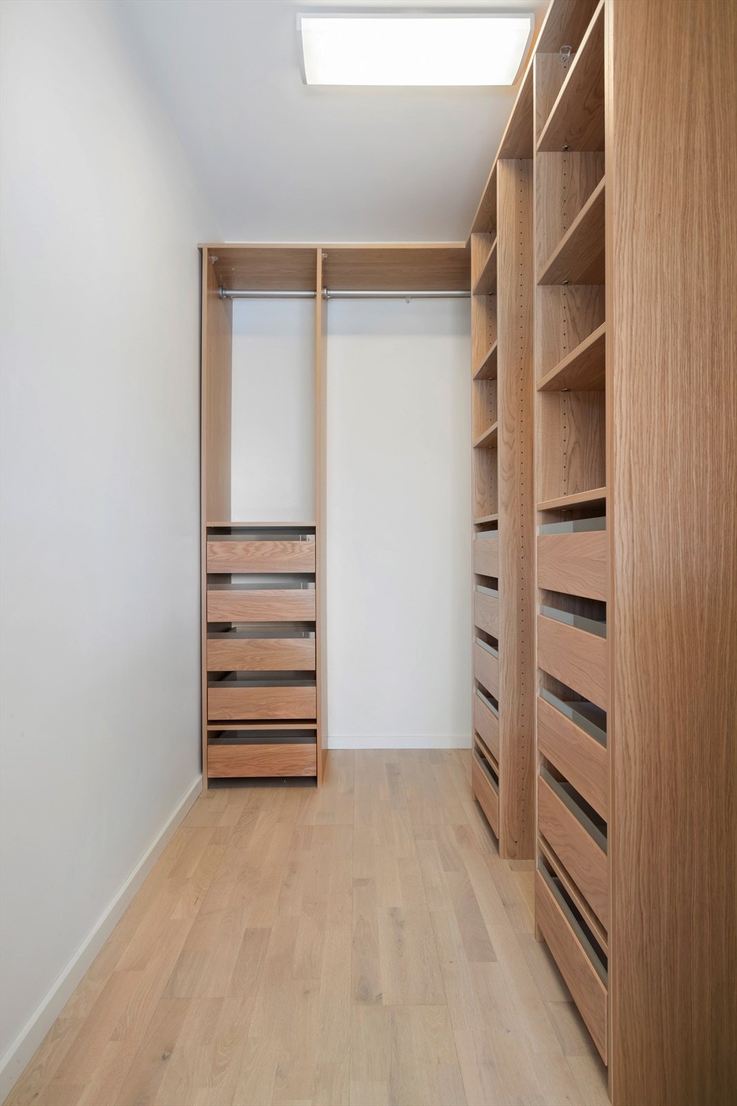 Praktisk walk-in garderobe med spesialtilpasset garderobeskap Galleribilde