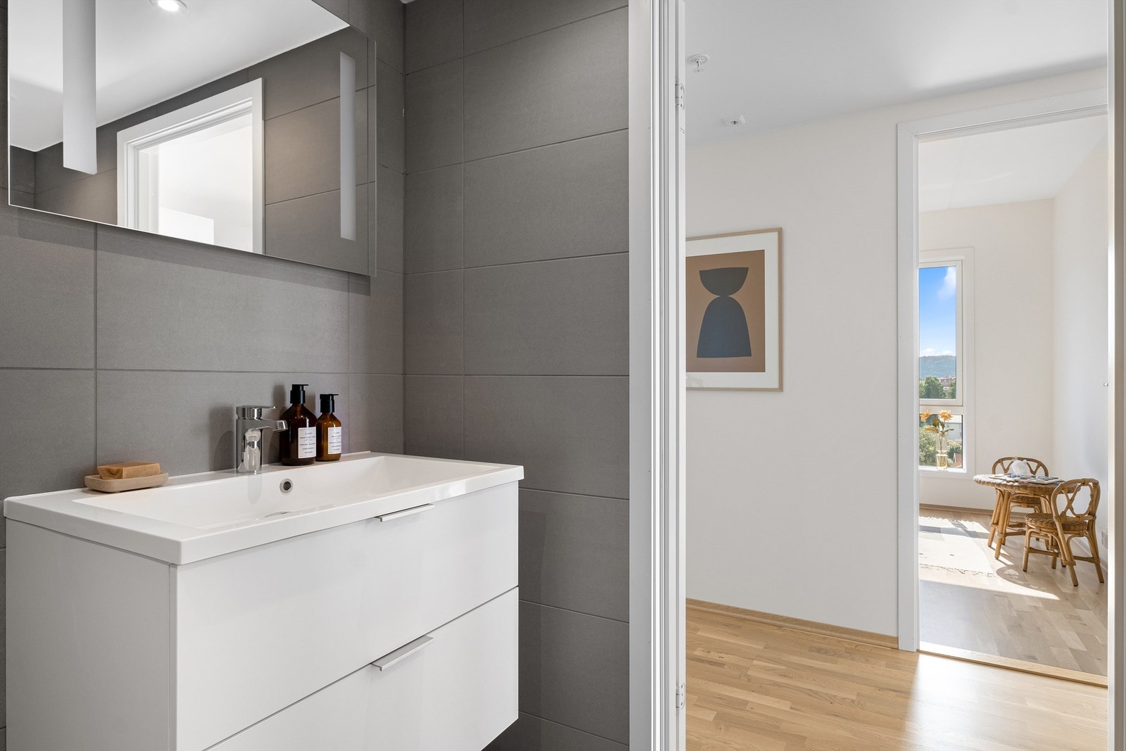 Videre består innredningen av heldekkende servant med ettgreps blandebatteri og speil med belysning på vegg. Med skuffeseksjoner under servanten har du god plass til oppbevaring. Galleribilde