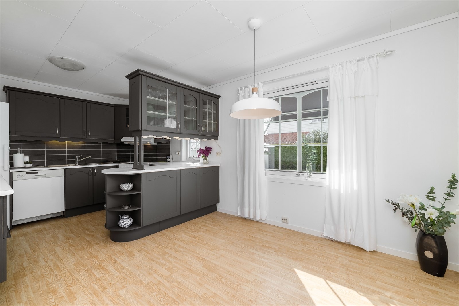 tilknytning til stuen ligger det et kjøkken med god plass for spisestue. Her er det eldre kjøkkeninnredning med profilerte fronter, som ble malt for ca. 2 år siden i en mørk, stilig farge. Det ble da også satt inn ekstra innredning. Galleribilde