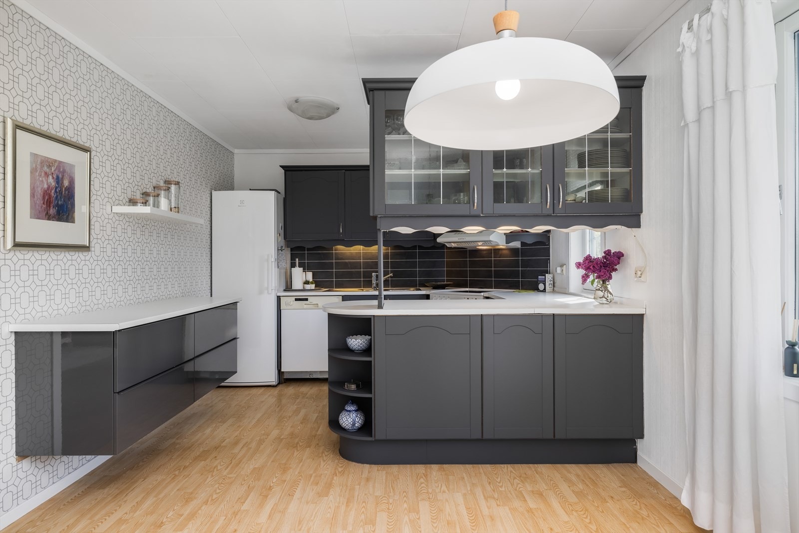Det er laminat benkeplate med nedfelt oppvaskkum i rustfritt stål. Opplegg og plass for oppvaskmaskin, komfyr og kjøleskap. Avtrekk over kokesone med utkast ut til yttervegg. Galleribilde