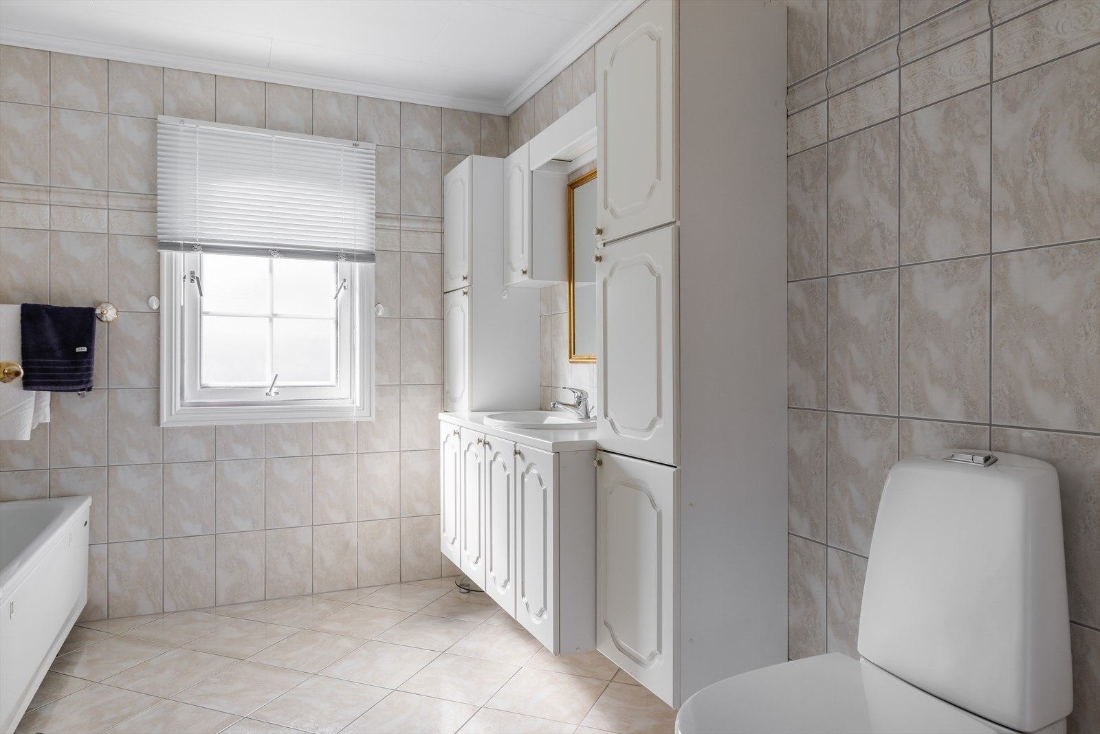 Badet er romslig og har fliser på gulv- og veggflater, med varmekabler i gulv. Galleribilde