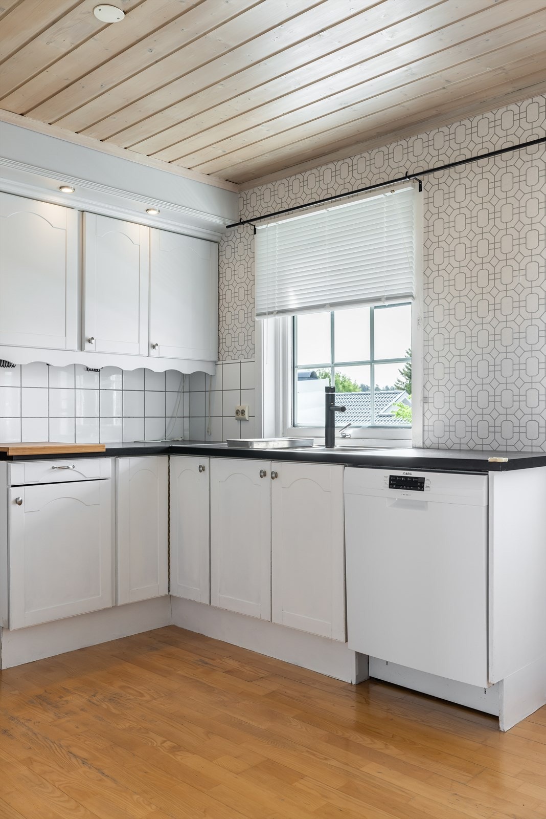 Laminat benkeplate, med flis på vegg over flatene og nedfelt oppvaskkum i rustfritt stål. Galleribilde