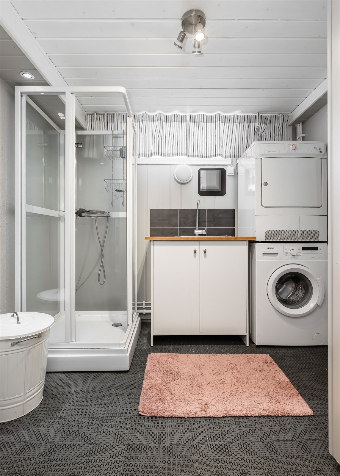 I kjeller er det også innredet et pent vaskerom hvor det er mdf-plater og noe malt puss på vegger, hvitmalt panel i tak og betonggulv hvor det er lagt PVC-matter oppå. Galleribilde