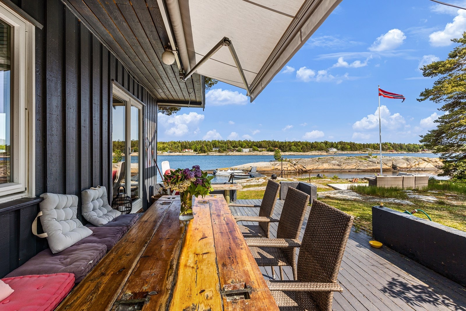 Verandaen har markise mot syd og trapp ned til hage både mot øst og vest. Galleribilde