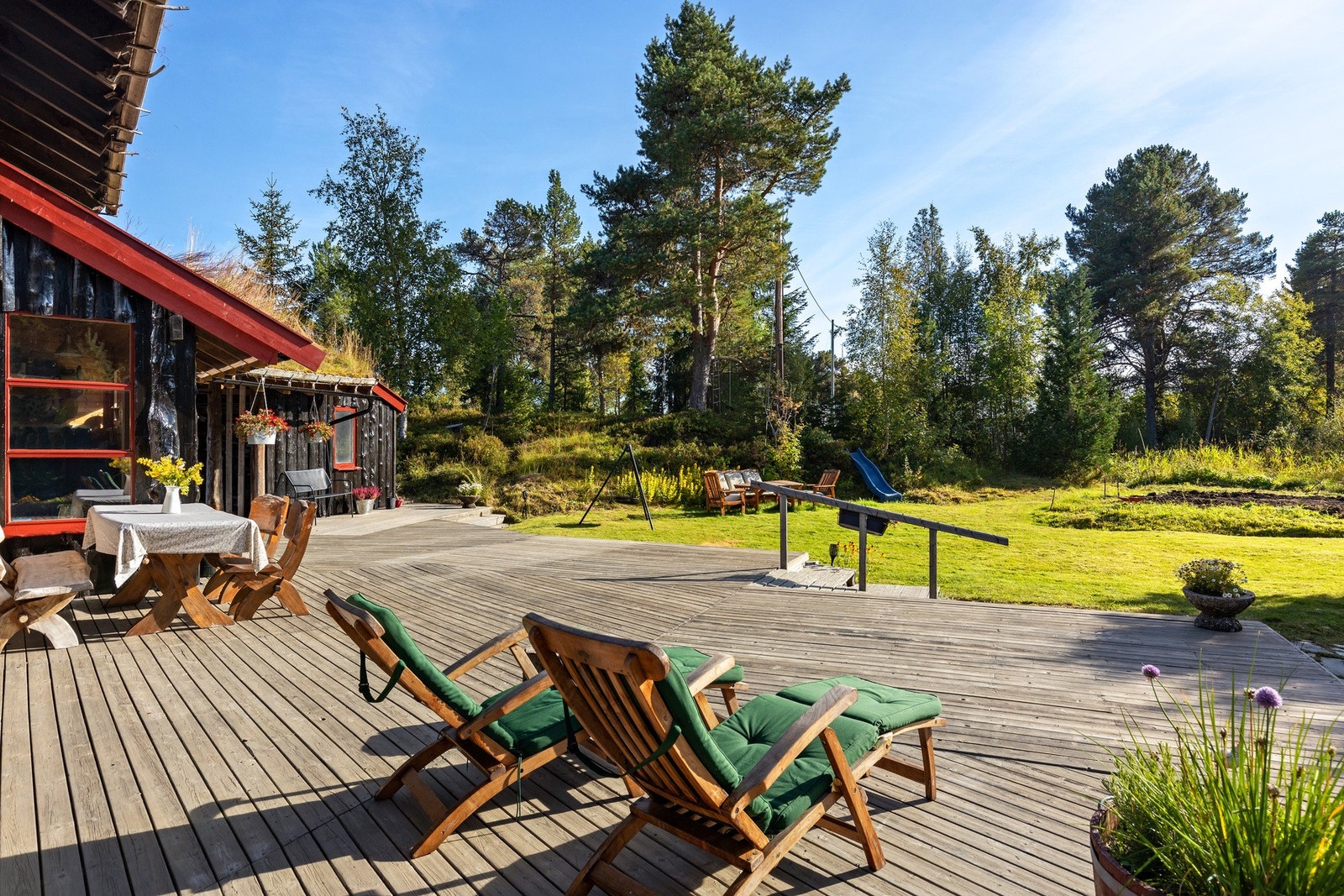 Stor solrik terrasse rundt huset i frodige og private omgivelser. Galleribilde