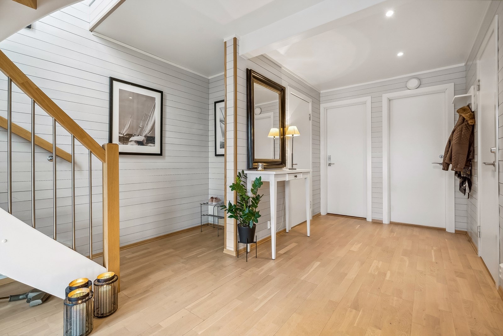 Romslig hall, hvor det er god plass til å sette fra seg sko og henge av seg yttertøy. Galleribilde