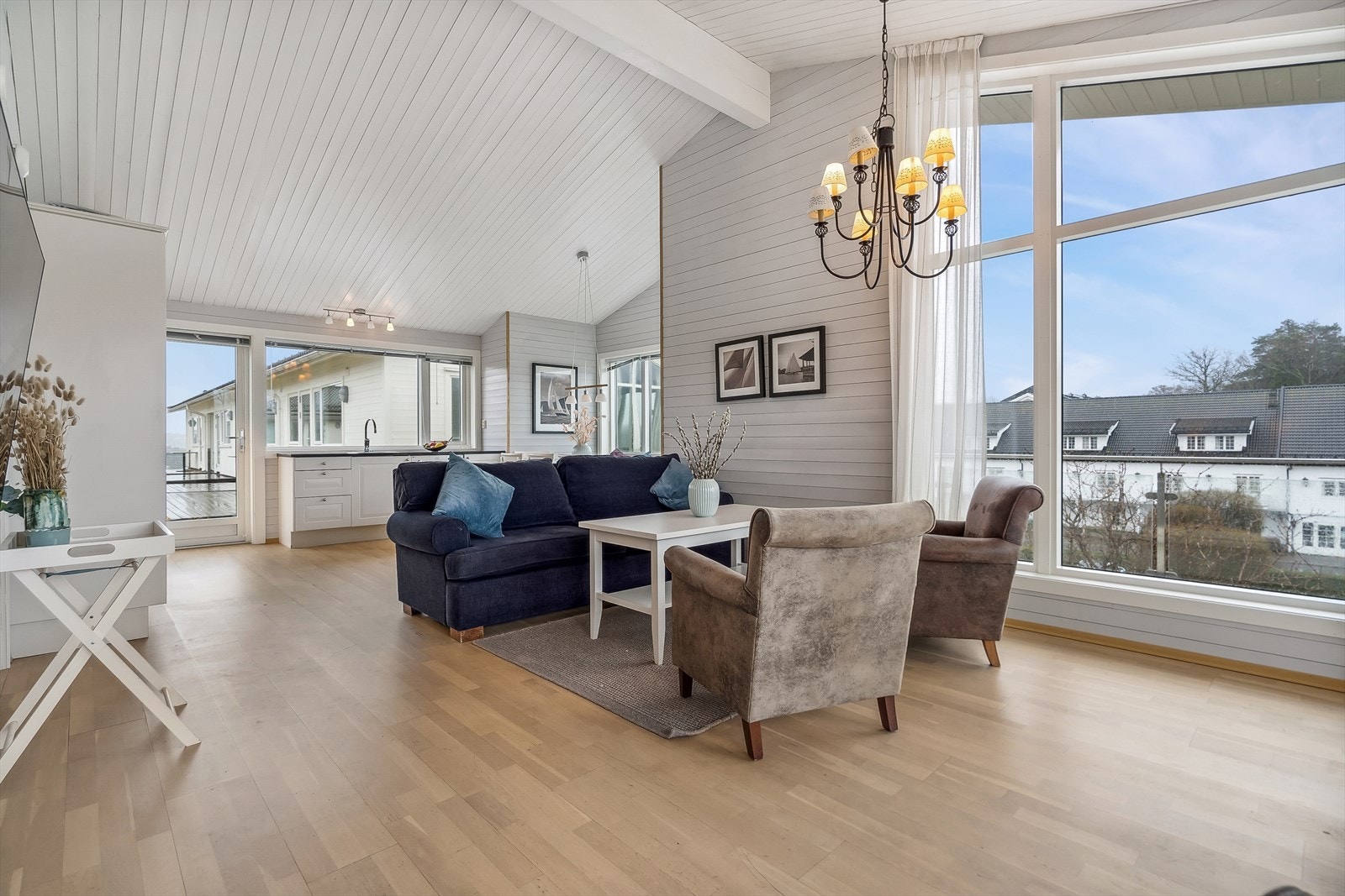 Stue og kjøkken i åpen løsning som gir en fantastisk romfølelse - her er det store vindusflater som slipper inn rikelig med sol- og dagslys. En herlig atmosfære! Galleribilde