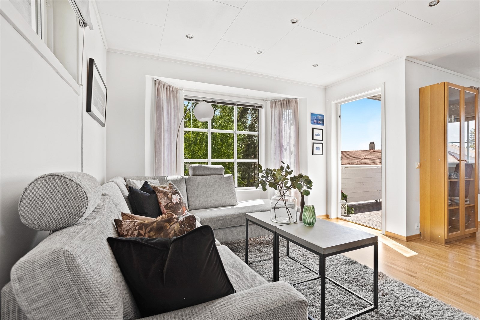 Utgang fra stue til delvis overbygd (ca 5 m²) balkong med tregulv, lys og rekkverk. Størrelse ca 21 m². Galleribilde