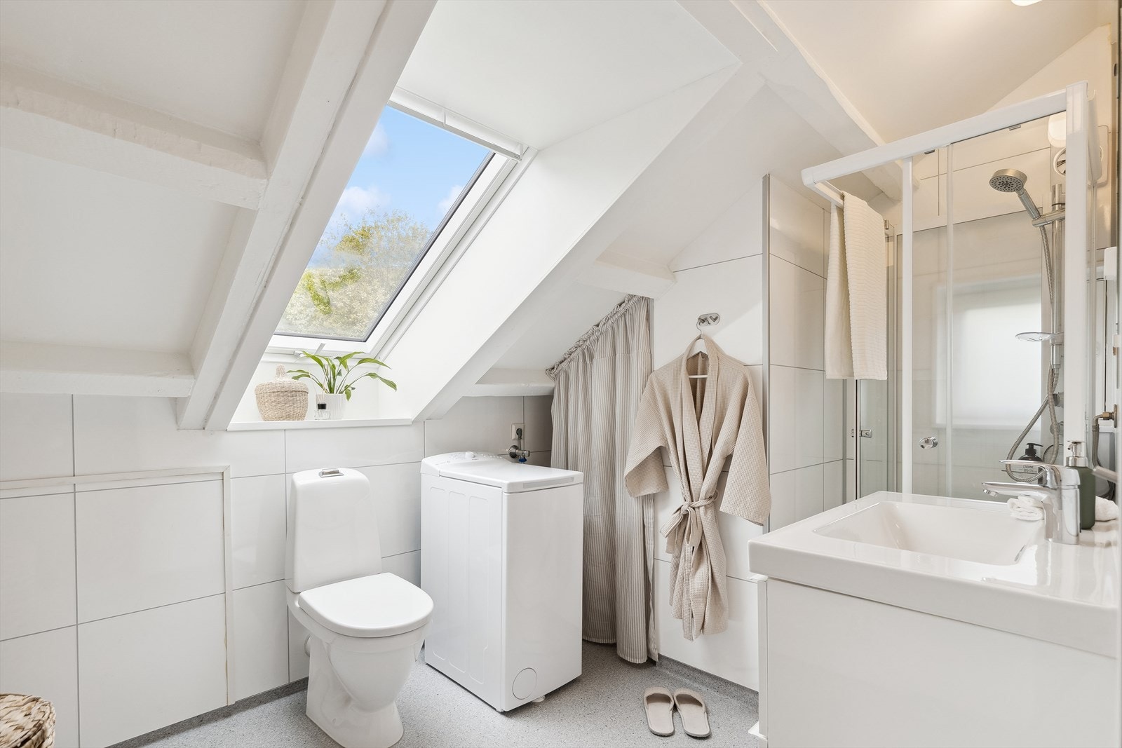 Lyst og pent bad/wc (2018) på loftet med dusjkabinett, servant og uttak for vaskemaskin. Galleribilde