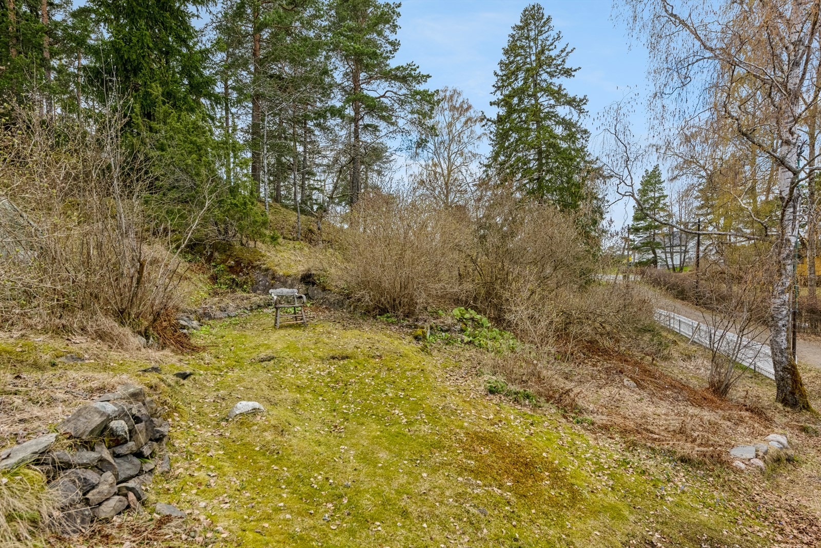 Tomten rundt fritidsboligen er opparbeidet med noe gress, stuer og terrasse. Ellers er det naturtomt Galleribilde