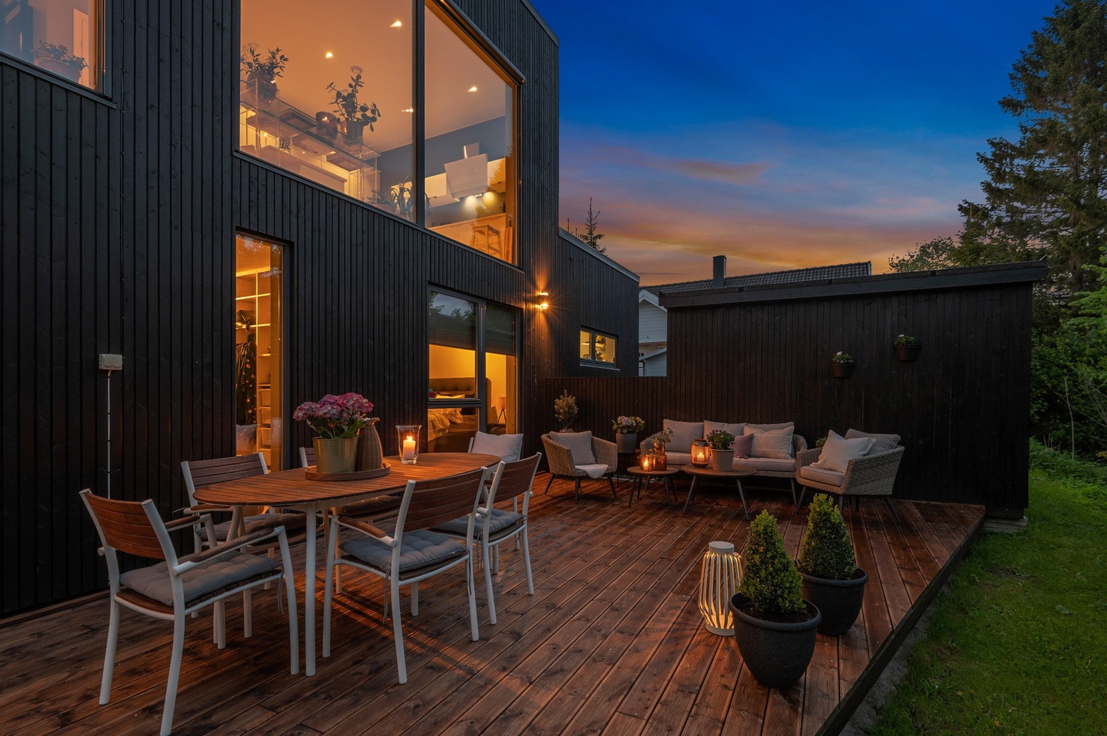 Avskjermet markterrasse på baksiden av huset. Nydelig opparbeidet med plen og beplantning. Galleribilde