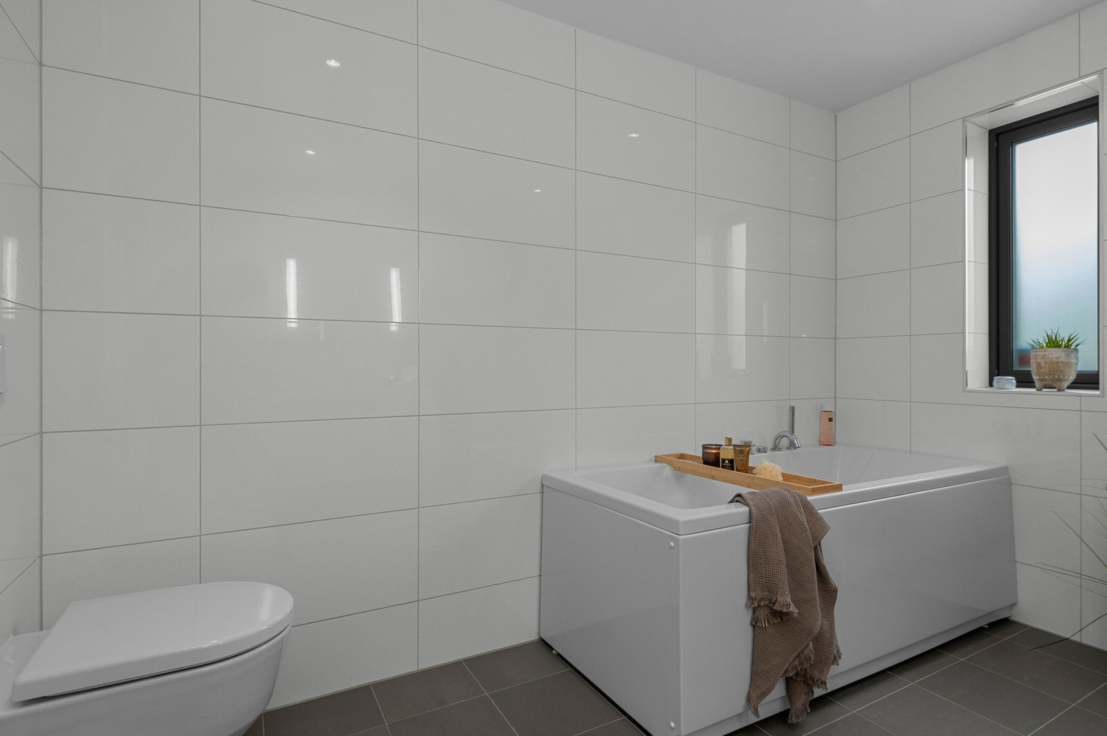 Badet er romslig og delikat innredet. Vegghengt wc og badekar. Galleribilde