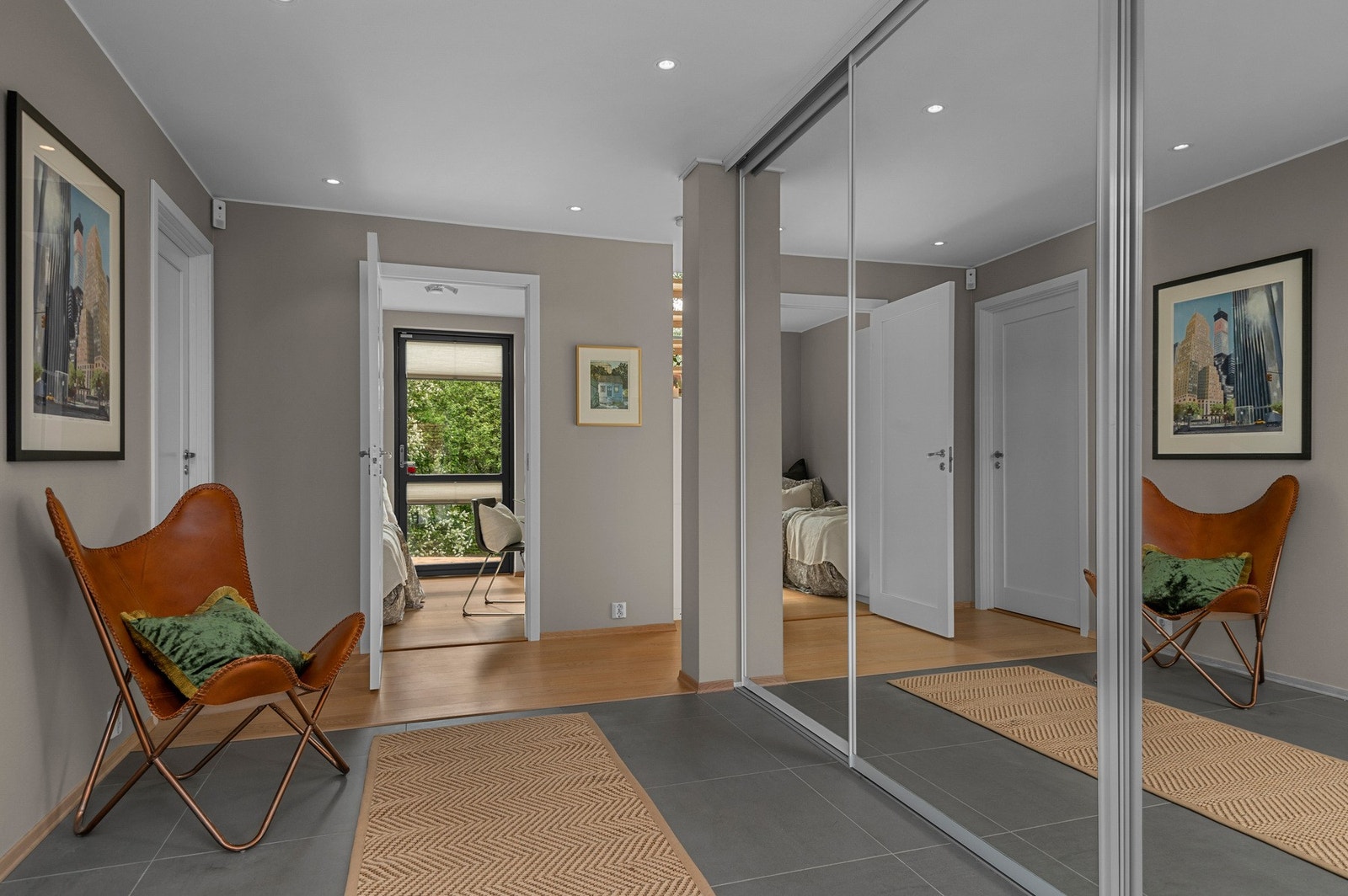 Inngangspartiet er delikat innredet med store fliser og varme i gulv. I tillegg er det en stor skyvedørsgarderobe. Galleribilde