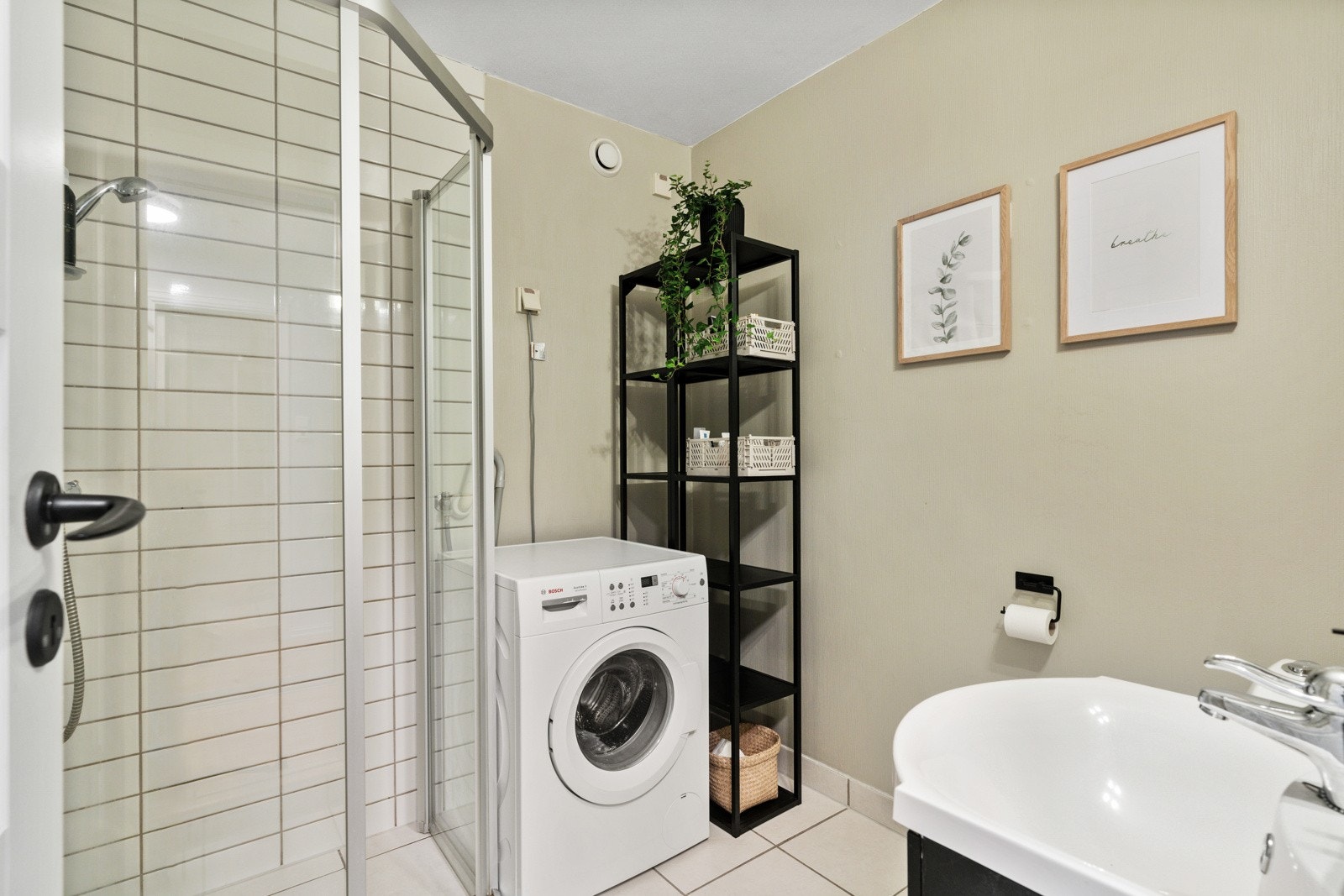 Bad med fliser på gulv og vegger i dusjsonen. Opplegg for vaskemaskin/tørketrommel. Galleribilde