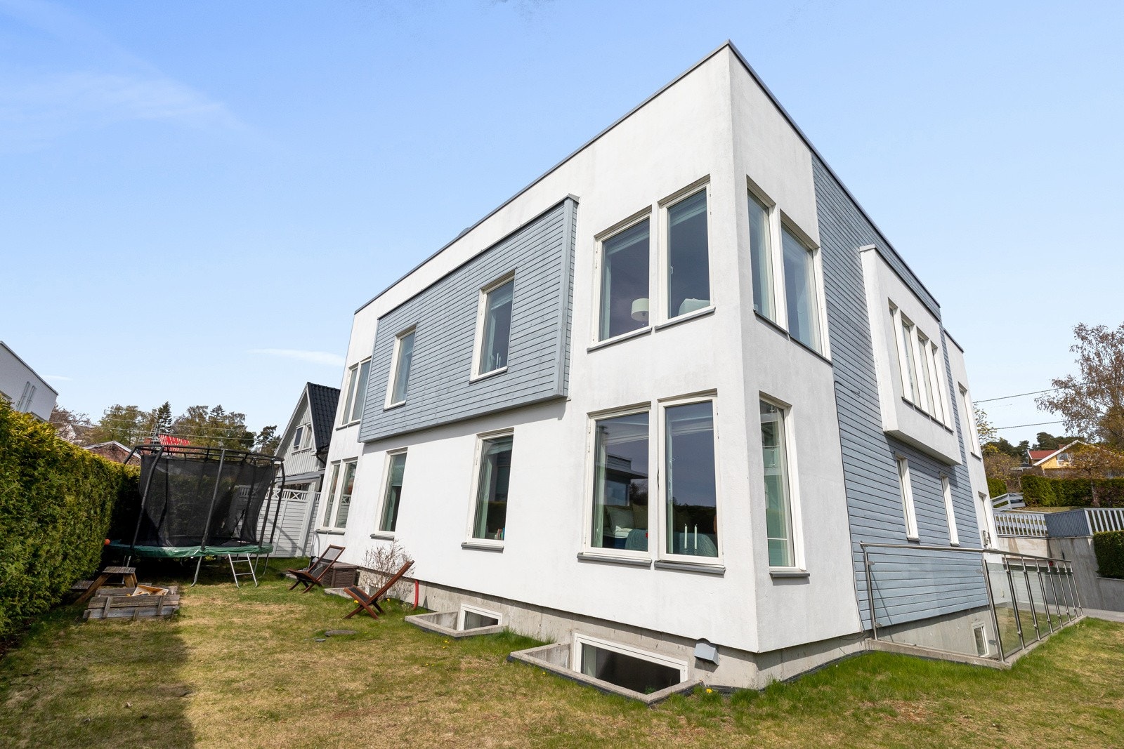 Boligen har en lettstelt hage opparbeidet med plen, høy hekk, belegningsstein og asfaltert areal foran inngangsparti. Galleribilde