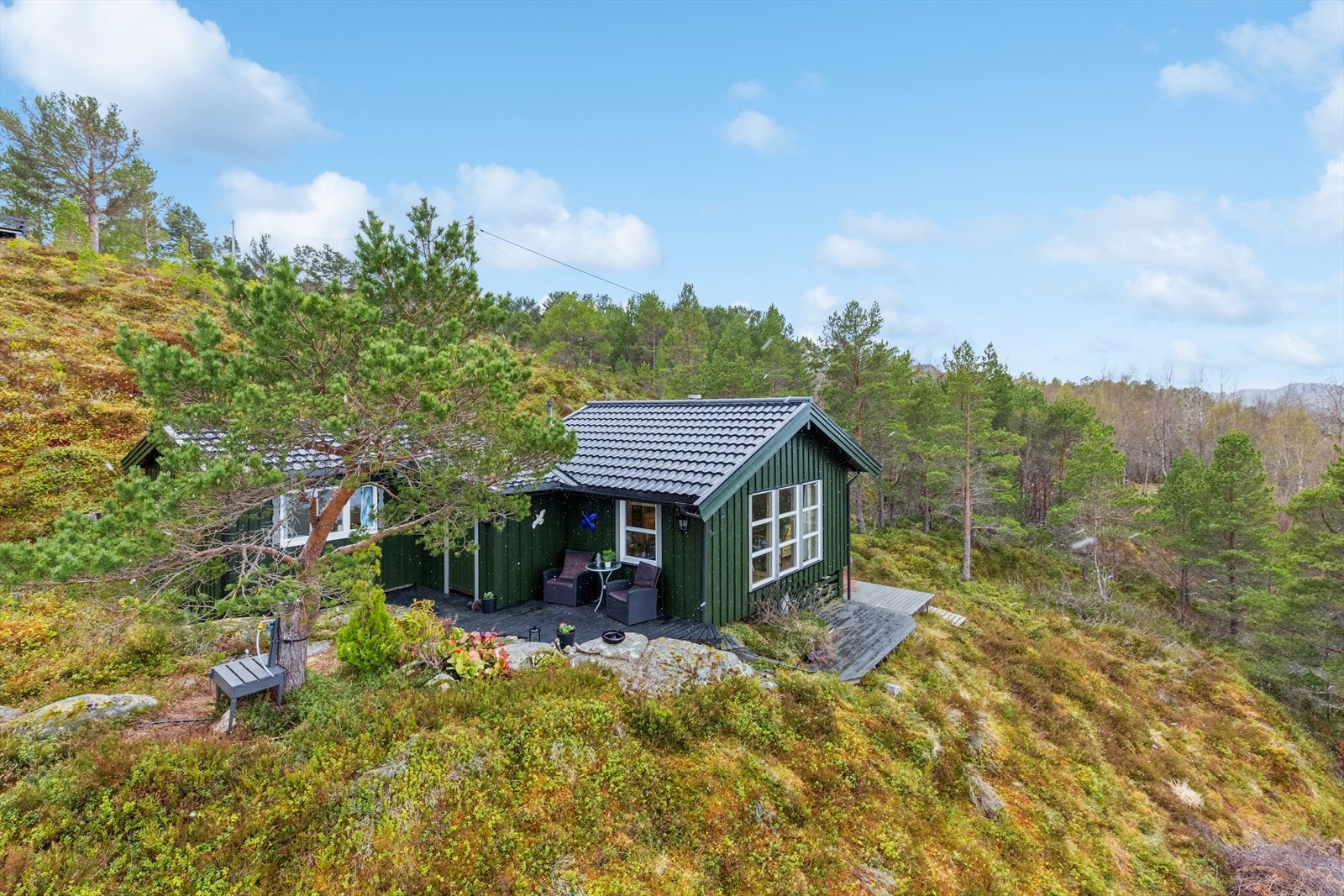 Eiendommen har en hyggelig naturtomt på omtrent 1023 kvm, med lyng, trær og noe fjell i dagen. Galleribilde
