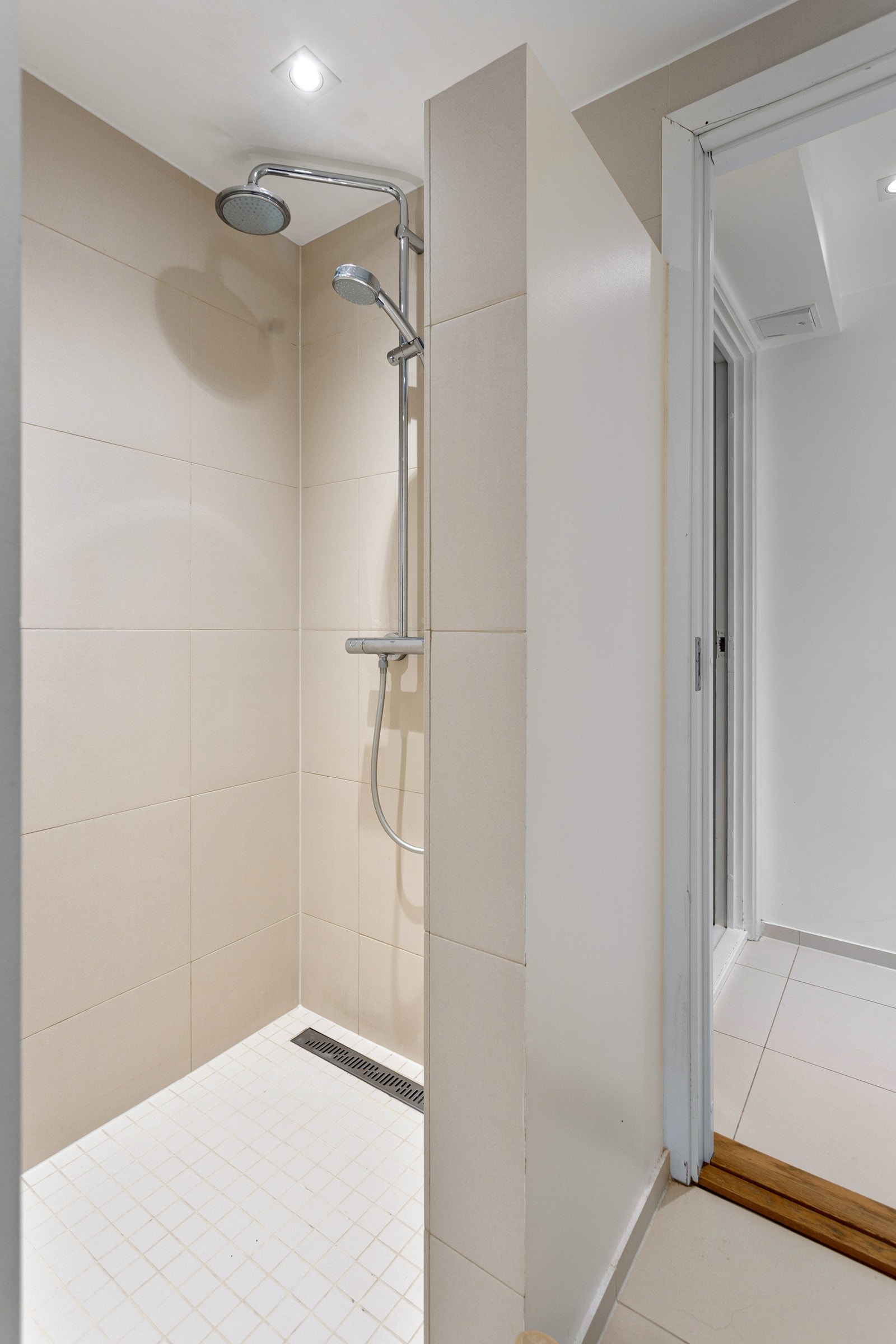 Badet er utstyrt med vegghengt wc, servant med skuffer under og dusj i hjørne. Galleribilde