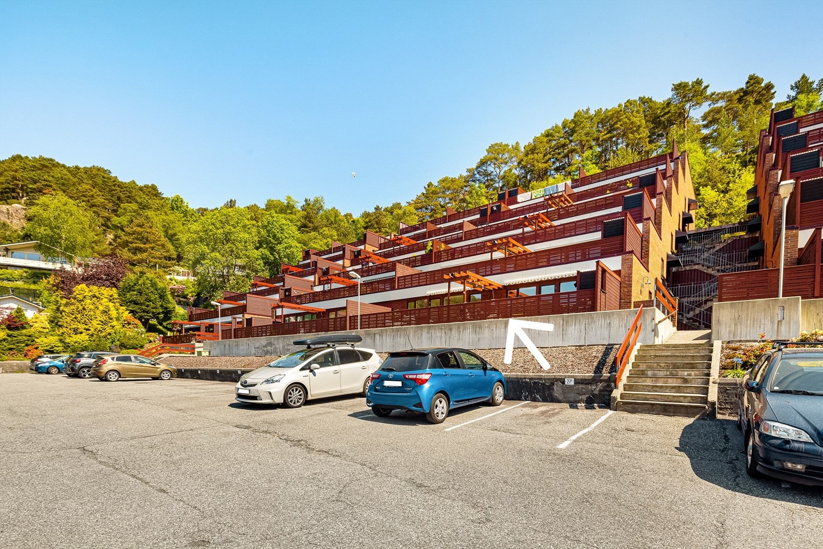 For av- og pålessing kan man kjøre helt til inngangsdøren. Det er også gjesteparkering på opp- og nedsiden av bygget. Galleribilde