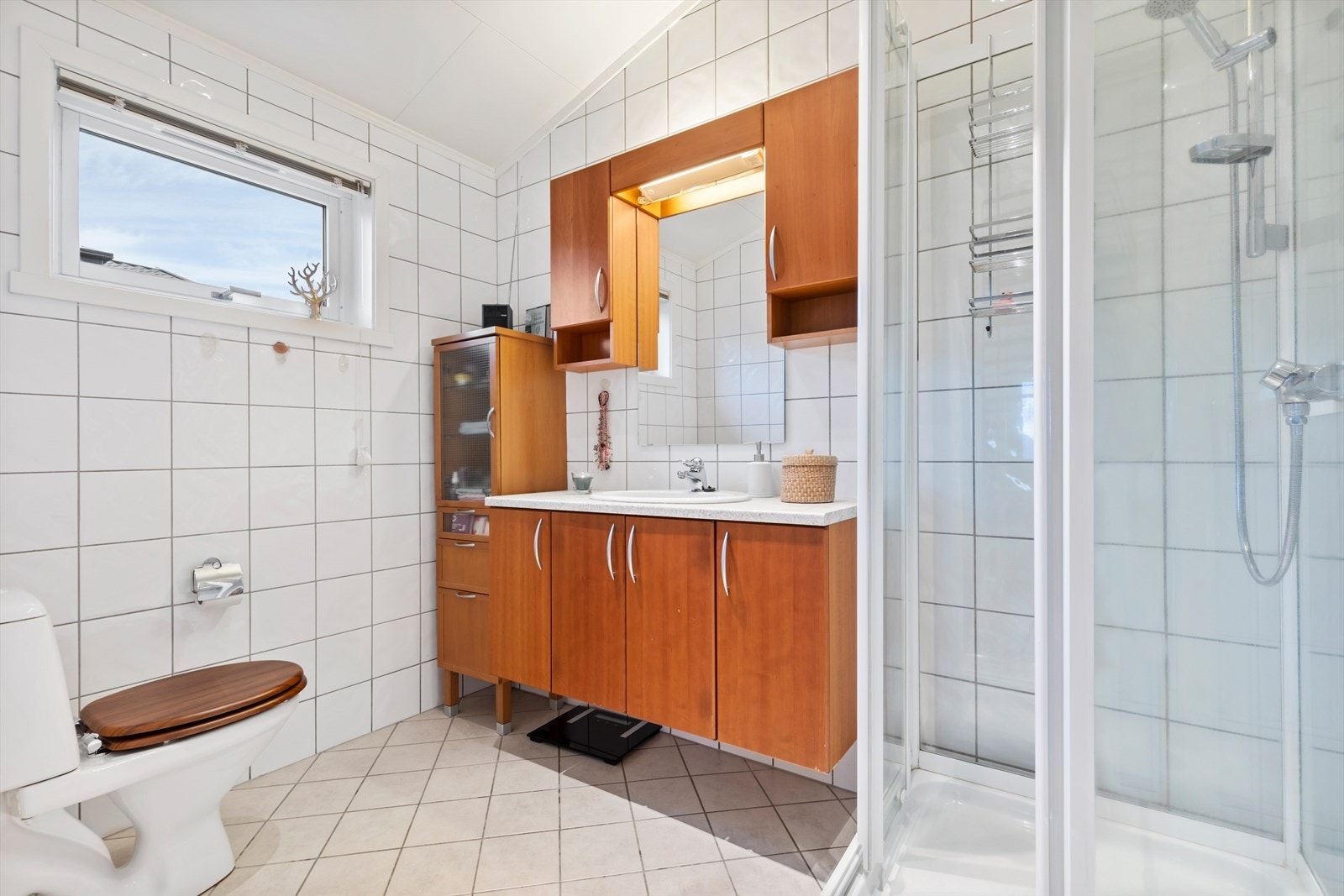 Her har du bad både i hovedetasjen og sokkeletasjen. Dette er badet i hovedetasjen, med fliser på vegger og gulv. Galleribilde