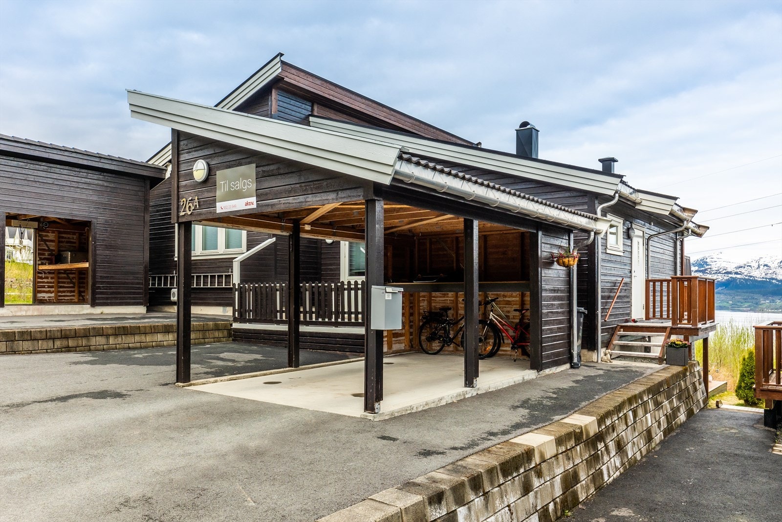 Det er både carport med oppbevaringsplass og parkeringsplass Galleribilde