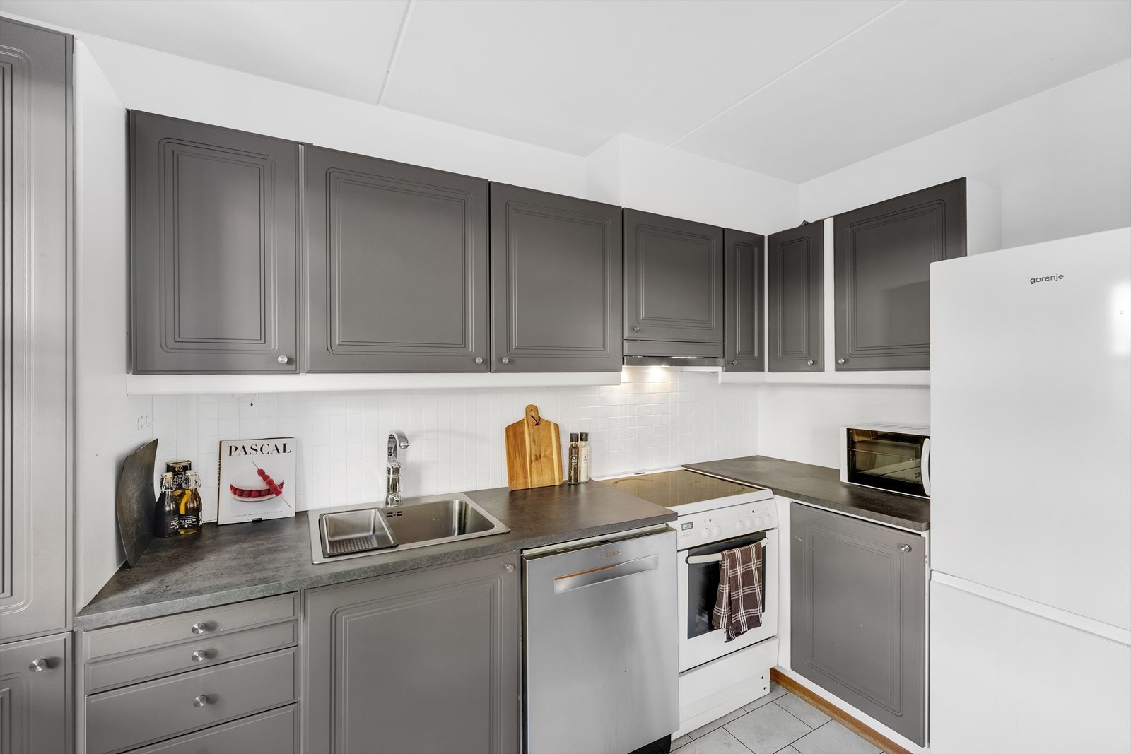 Pen kjøkkeninnredning med profilerte fronter og benkeplate i laminat. Galleribilde