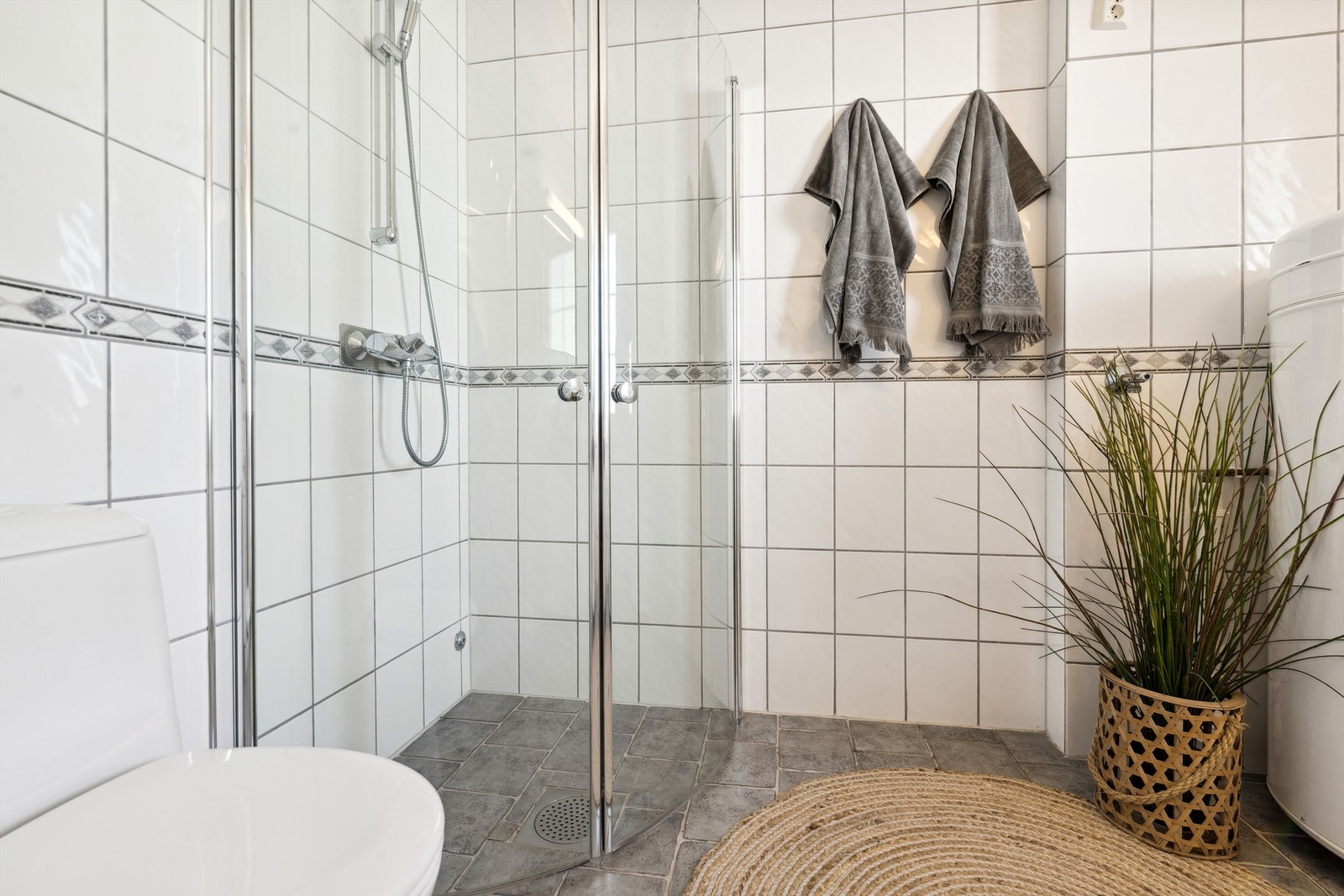 Badet er innredet med dusj på vegg, innfellbare dører og gulvmontert toalett. Opplegg for vaskemaskin er det også her. Galleribilde
